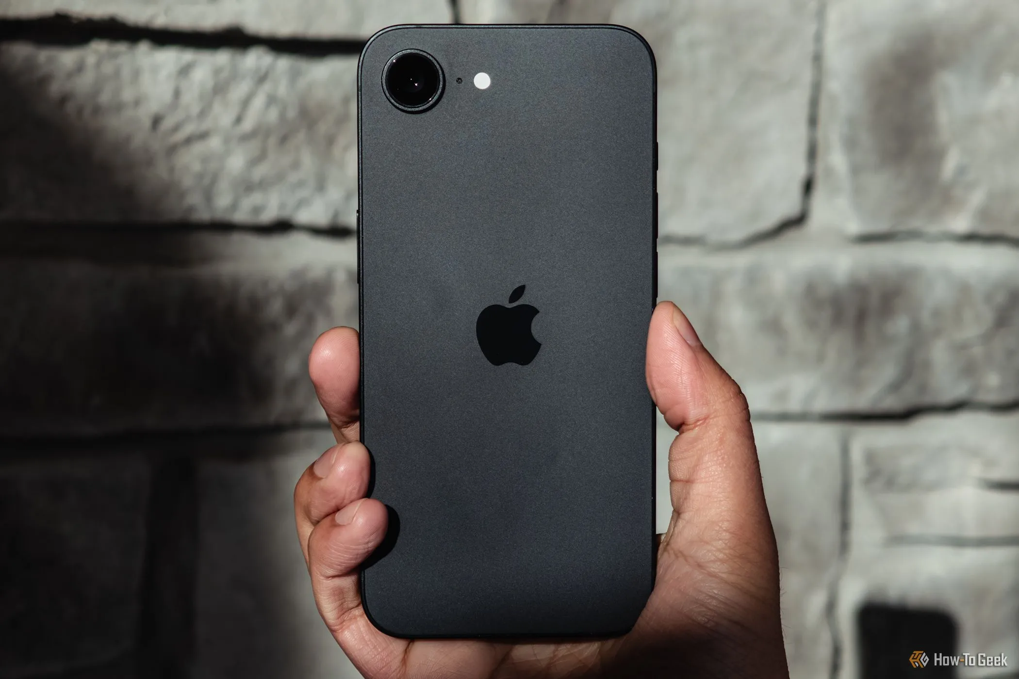 Hình ảnh minh họa chiếc iPhone - thiết bị sẽ nhận bản cập nhật iOS 26 mới - được cầm trên tay dưới ánh nắng.