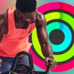 Huấn luyện viên Apple Fitness+ tập luyện trước màn hình hiển thị Vòng Hoạt động Apple Watch. Ảnh: How-To Geek / Apple