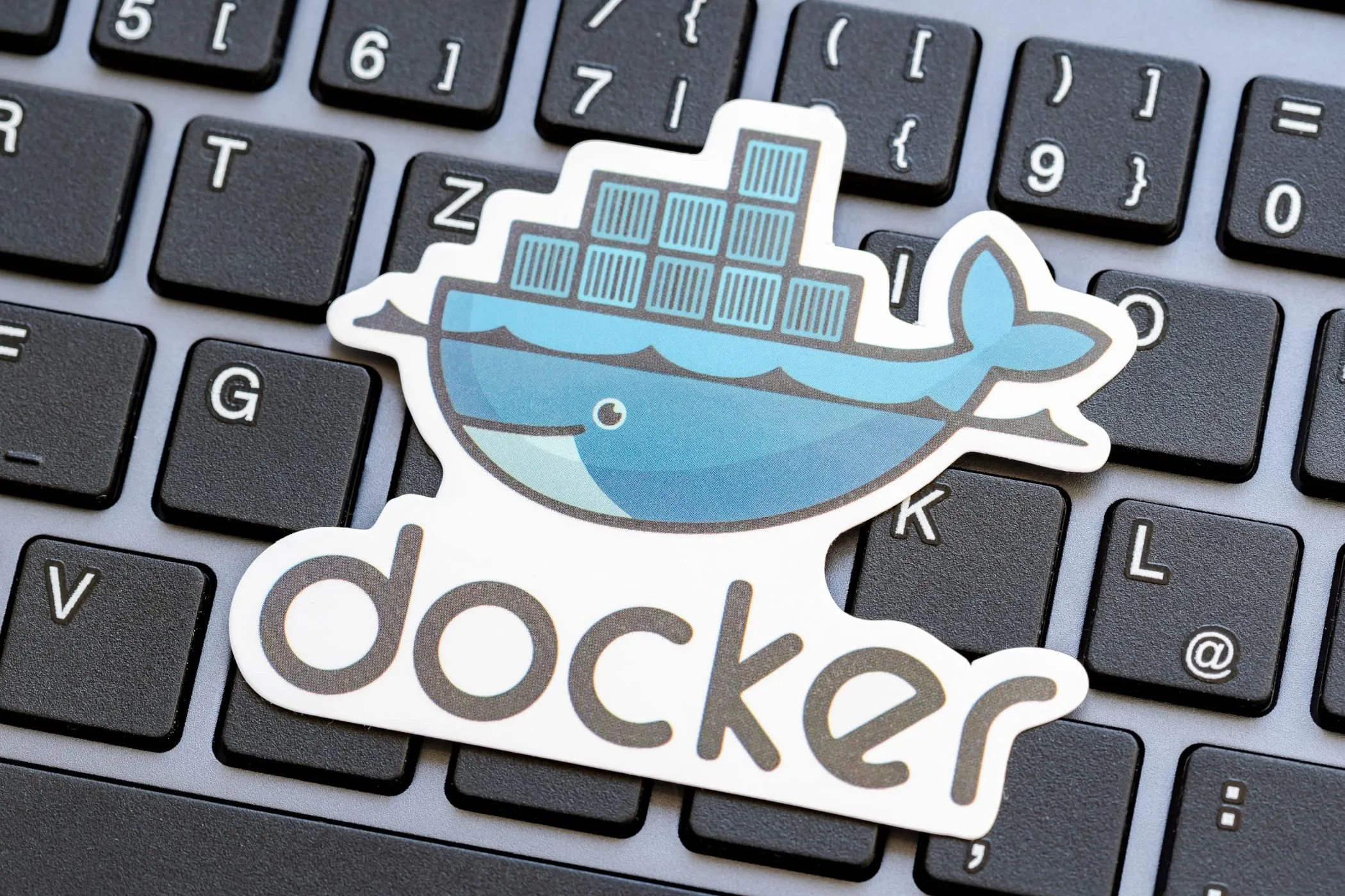Logo Docker trên bàn phím laptop, minh họa công cụ đơn giản hóa self-hosting các ứng dụng công nghệ