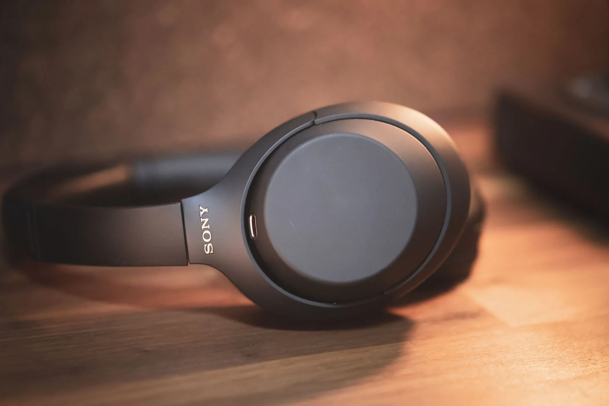Tai nghe chống ồn không dây Sony WH-1000XM4 màu đen đặt trên bàn làm việc.