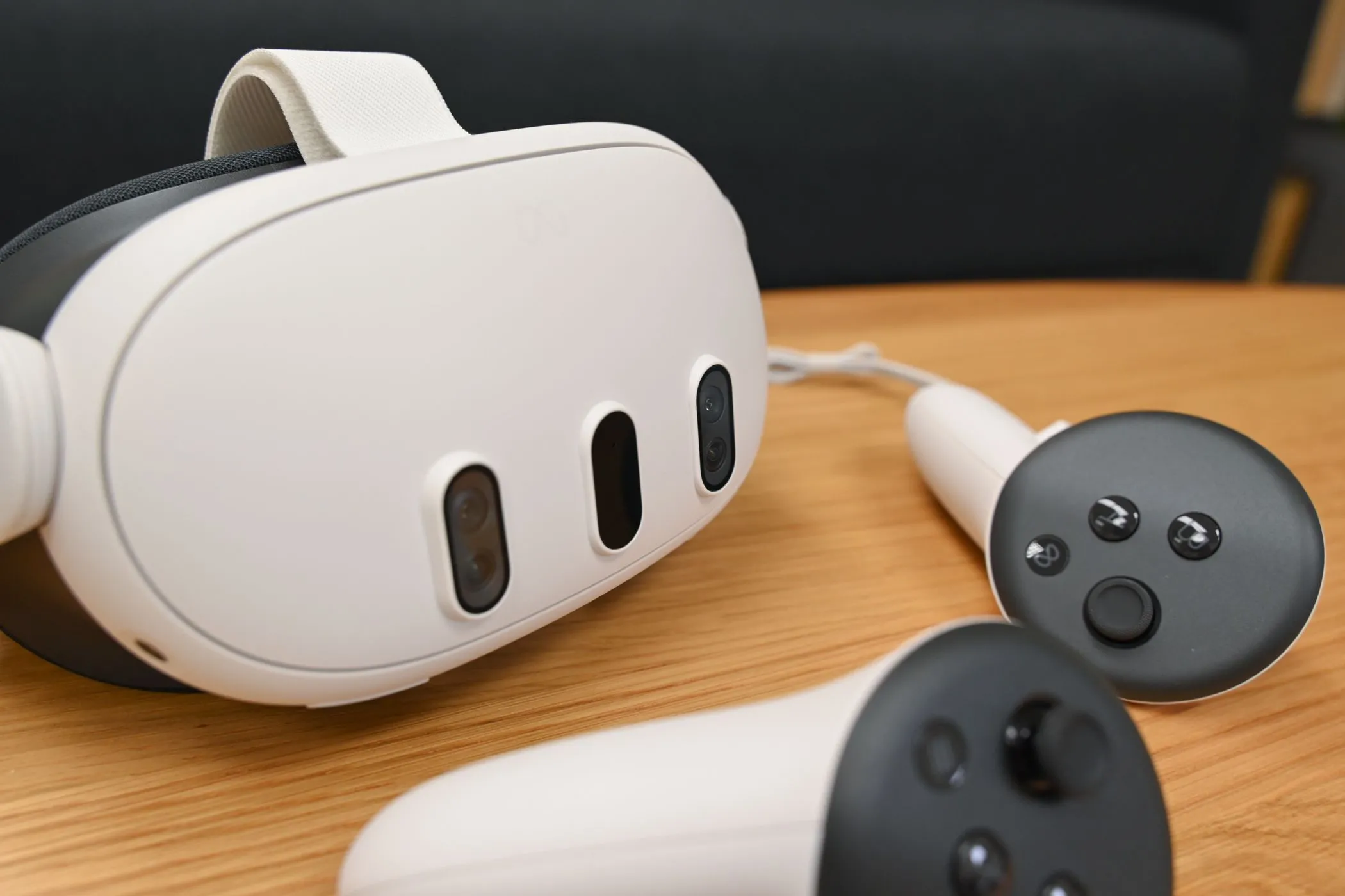 Tai nghe VR Meta Quest 3 và hai bộ điều khiển, đặt trên mặt phẳng.