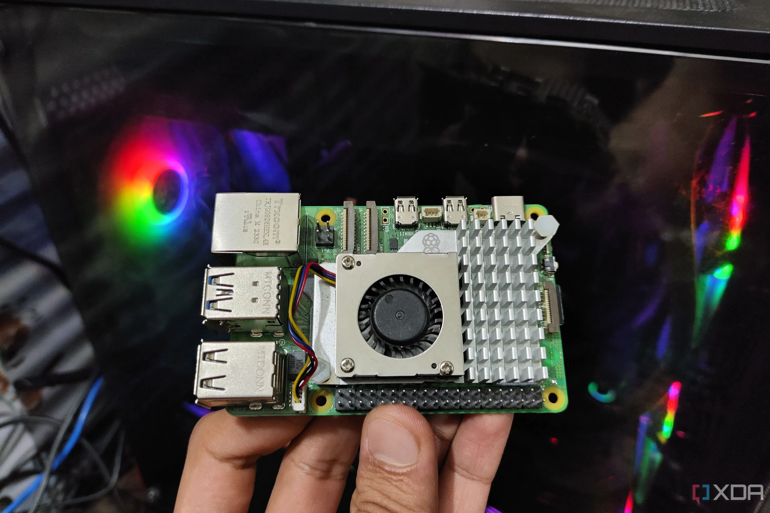 Một bo mạch Raspberry Pi 5 đặt trước màn hình máy tính, tượng trưng cho máy chủ tự lưu trữ hiệu quả