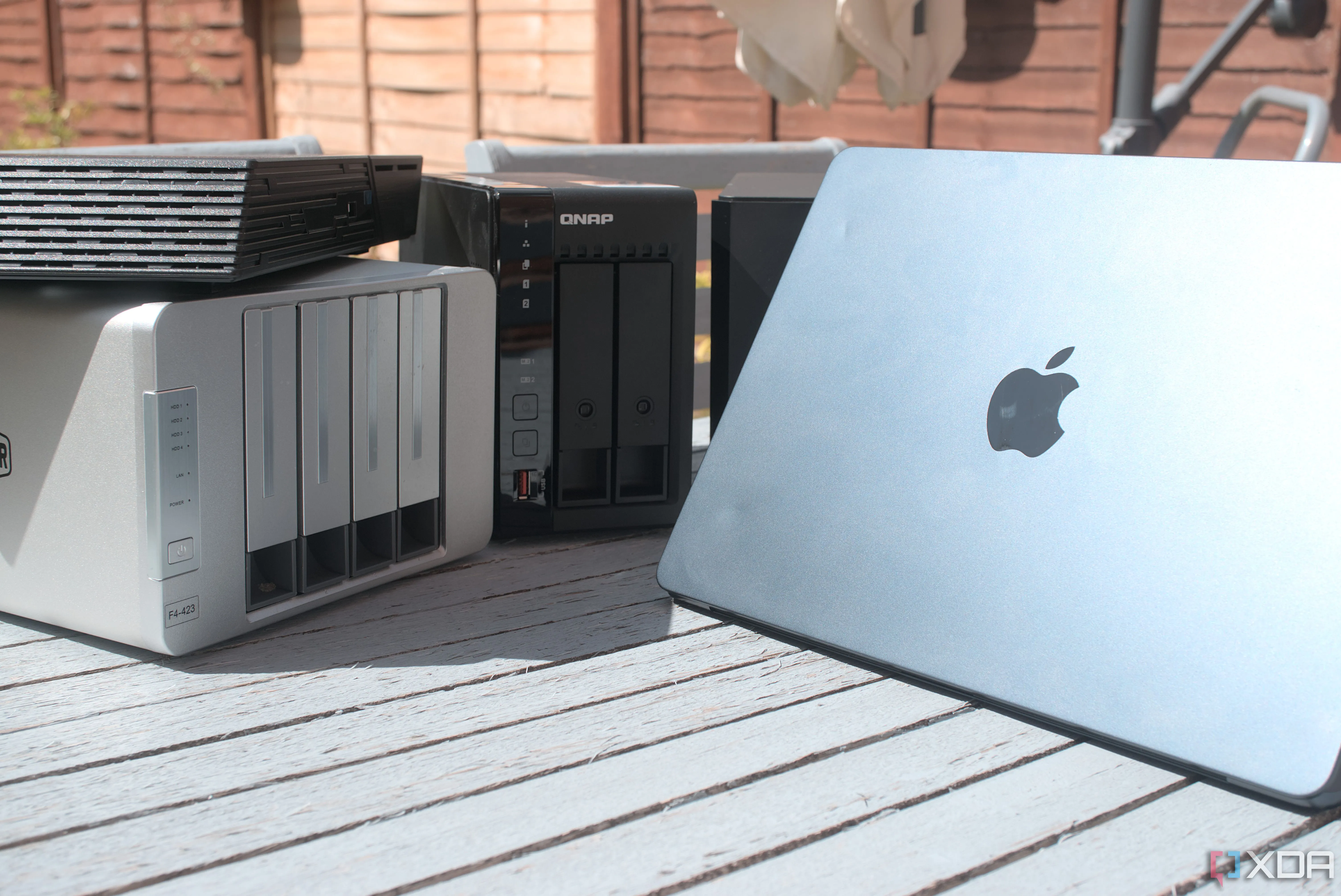 Một chiếc MacBook Air đặt cạnh thiết bị NAS, tượng trưng cho việc sao lưu dữ liệu.