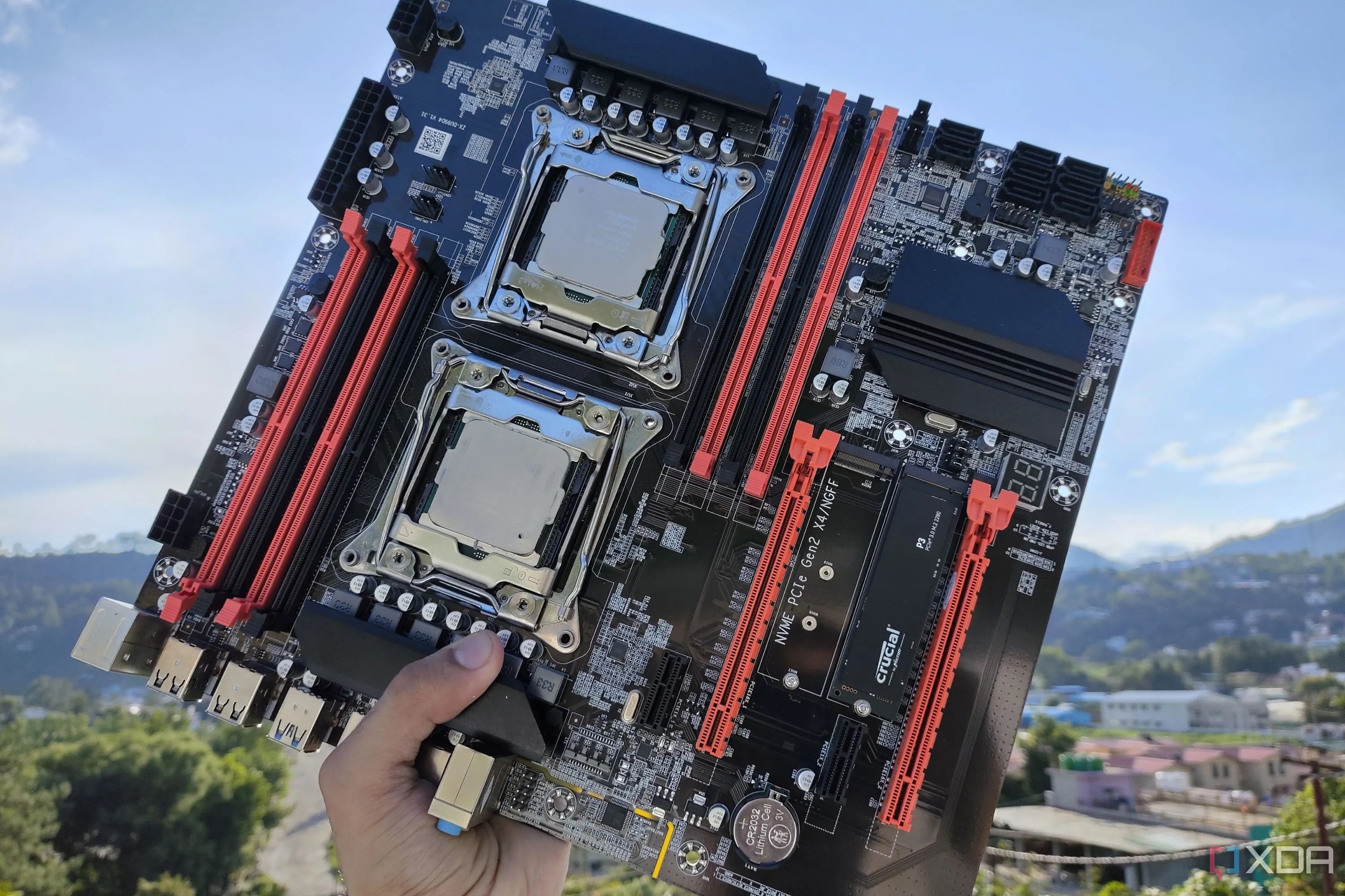 Một người đang cầm bo mạch chủ server X99 đã lắp hai CPU Intel Xeon