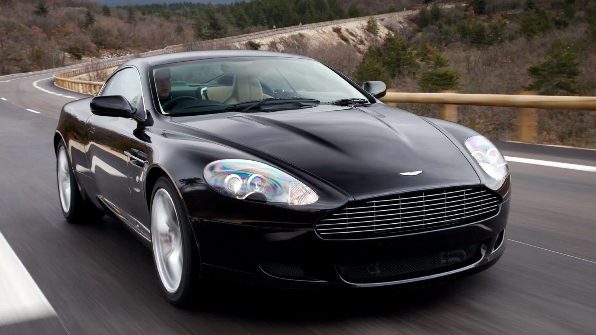 Aston Martin DB9 2007 màu đen sang trọng đang lăn bánh, góc nhìn 3/4 từ phía trước
