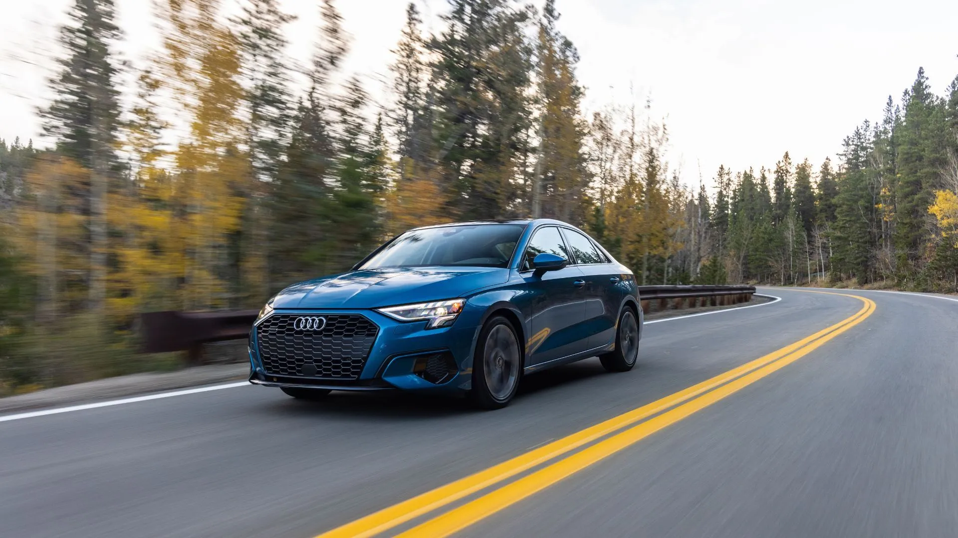 Audi A3 2025 màu xanh ngọc di chuyển trên đường quê, thể hiện sự sang trọng và công nghệ lái vượt trội