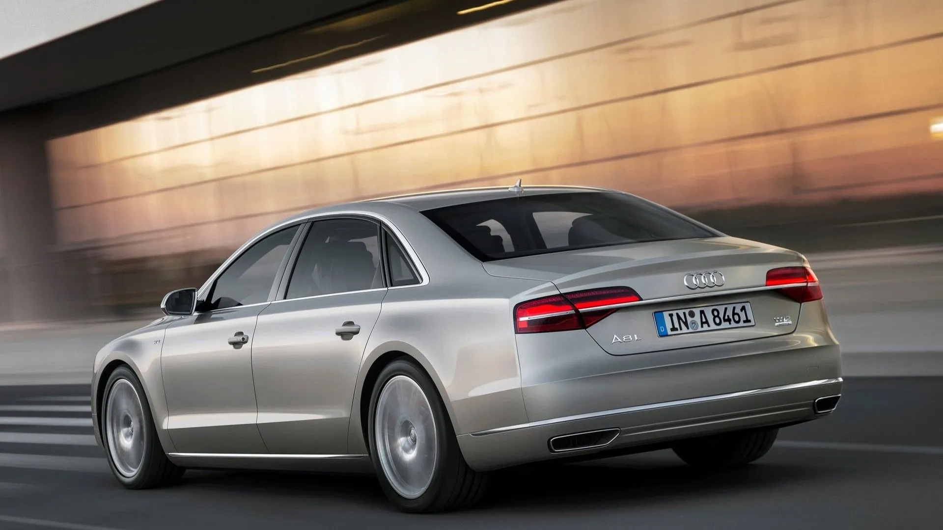 Audi A8 2018 màu bạc nhìn từ góc 3/4 phía sau đang di chuyển, nổi bật với thiết kế đuôi xe mạnh mẽ và sang trọng