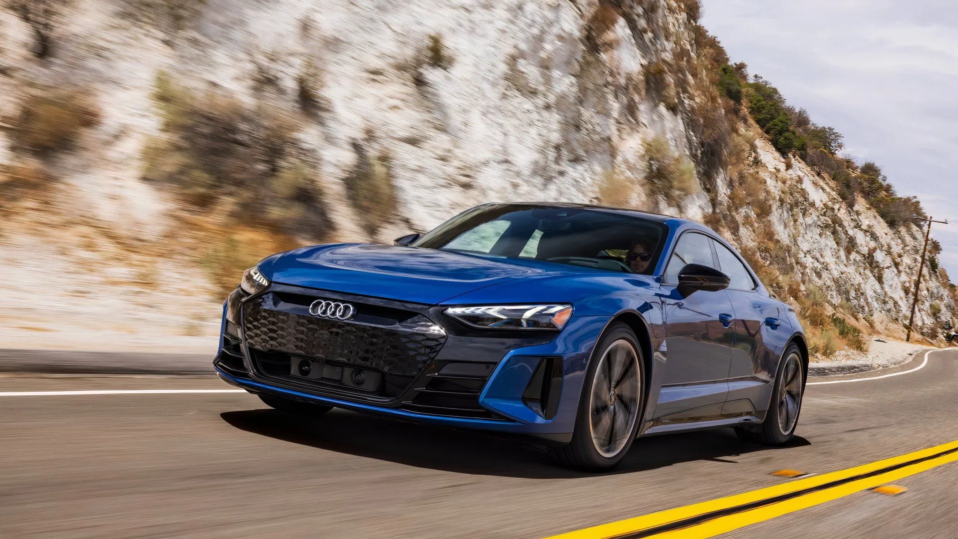 Audi e-tron GT 2024 màu xám đang di chuyển, một mẫu sedan thể thao điện sang trọng có tỷ lệ mất giá cao hơn đối thủ