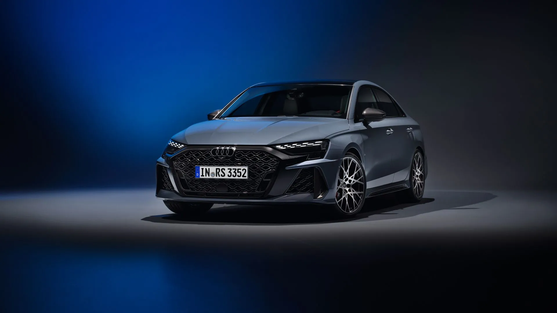 Audi RS3 2025 màu xám trong studio, thể hiện thiết kế mạnh mẽ của sedan thể thao