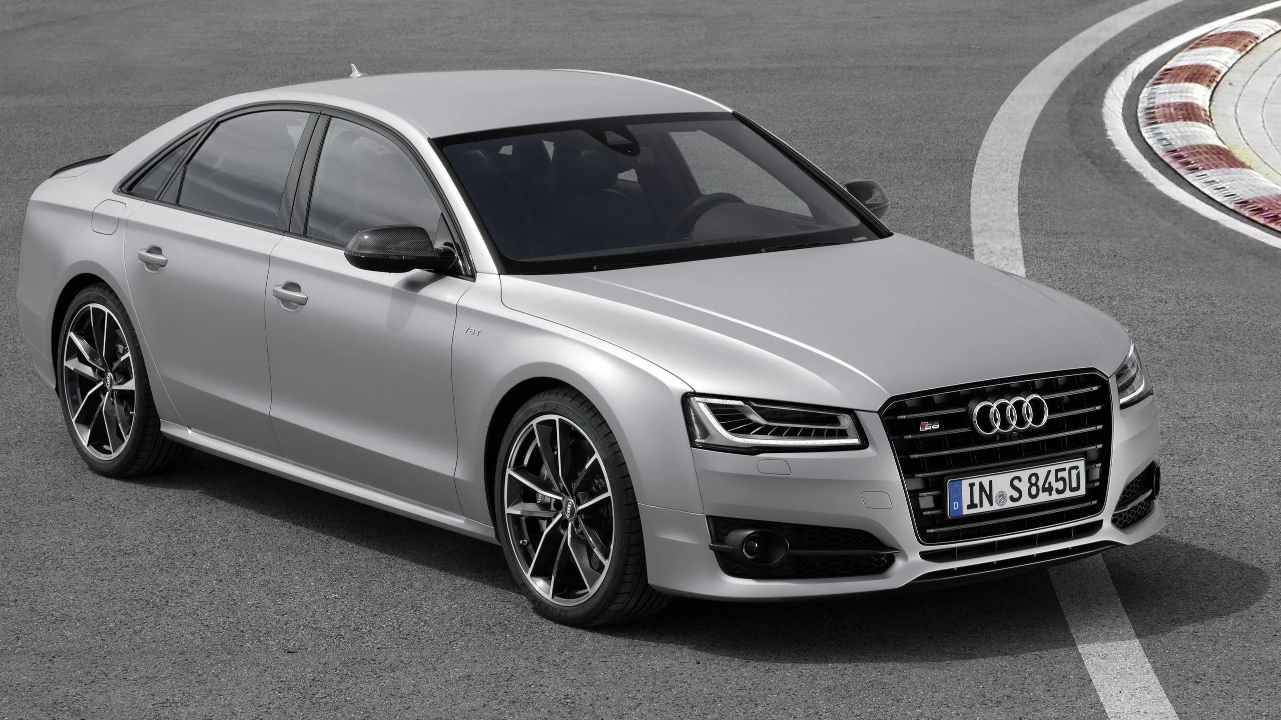 Audi S8 Plus 2016 màu xám bạc đang đậu trên đường đua, góc nhìn 3/4 từ phía trước, toát lên vẻ mạnh mẽ và sang trọng