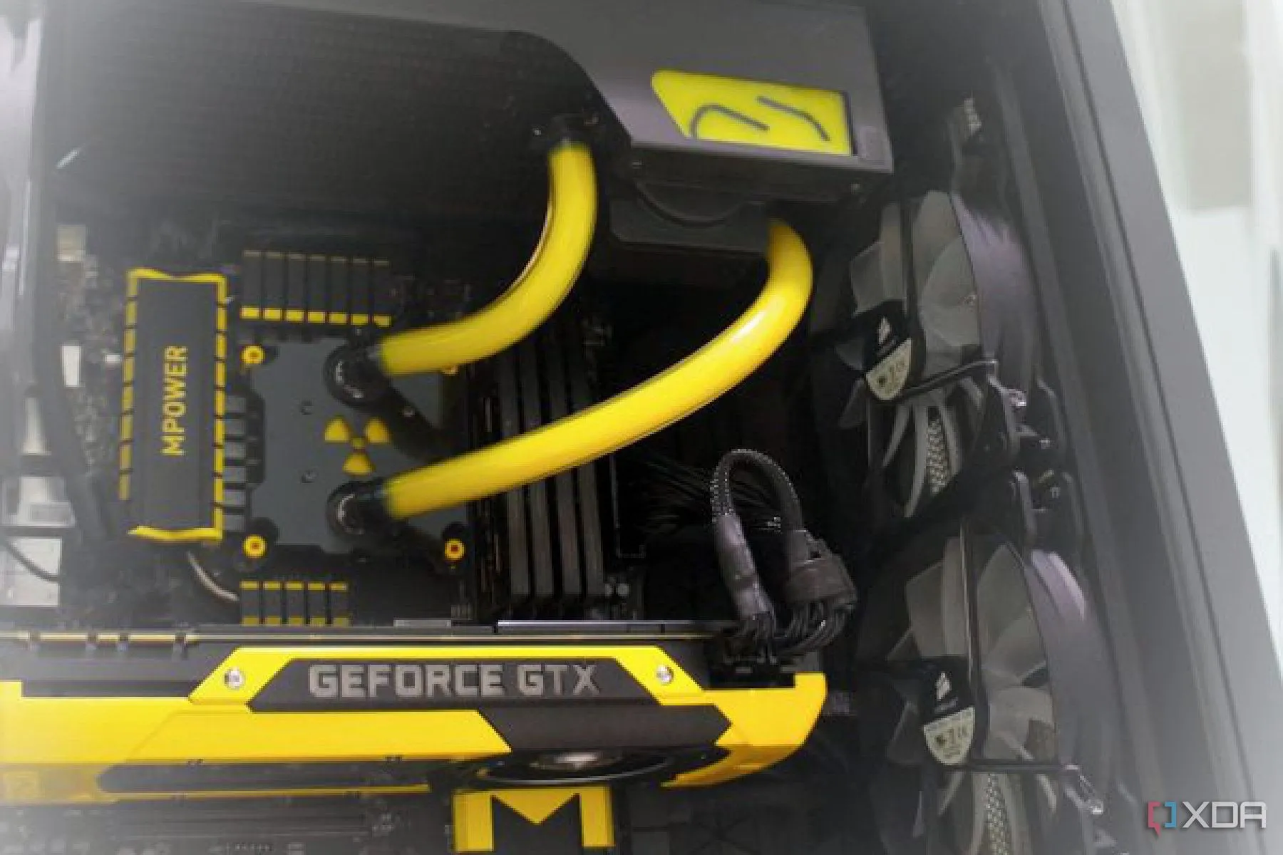 Bản build PC gaming với chủ đề vàng đen, cho thấy tản nhiệt AIO và quạt bên trong