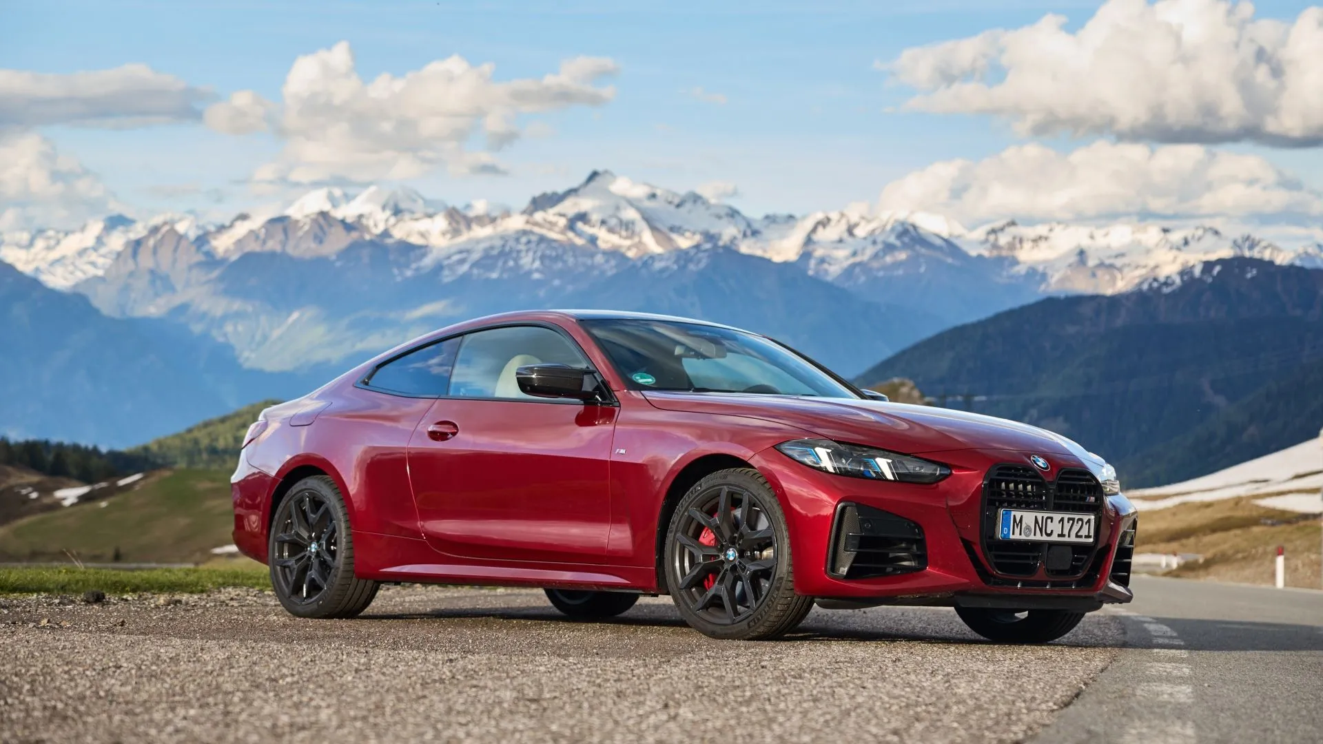 BMW 4-Series màu đỏ đỗ trước dãy núi hùng vĩ