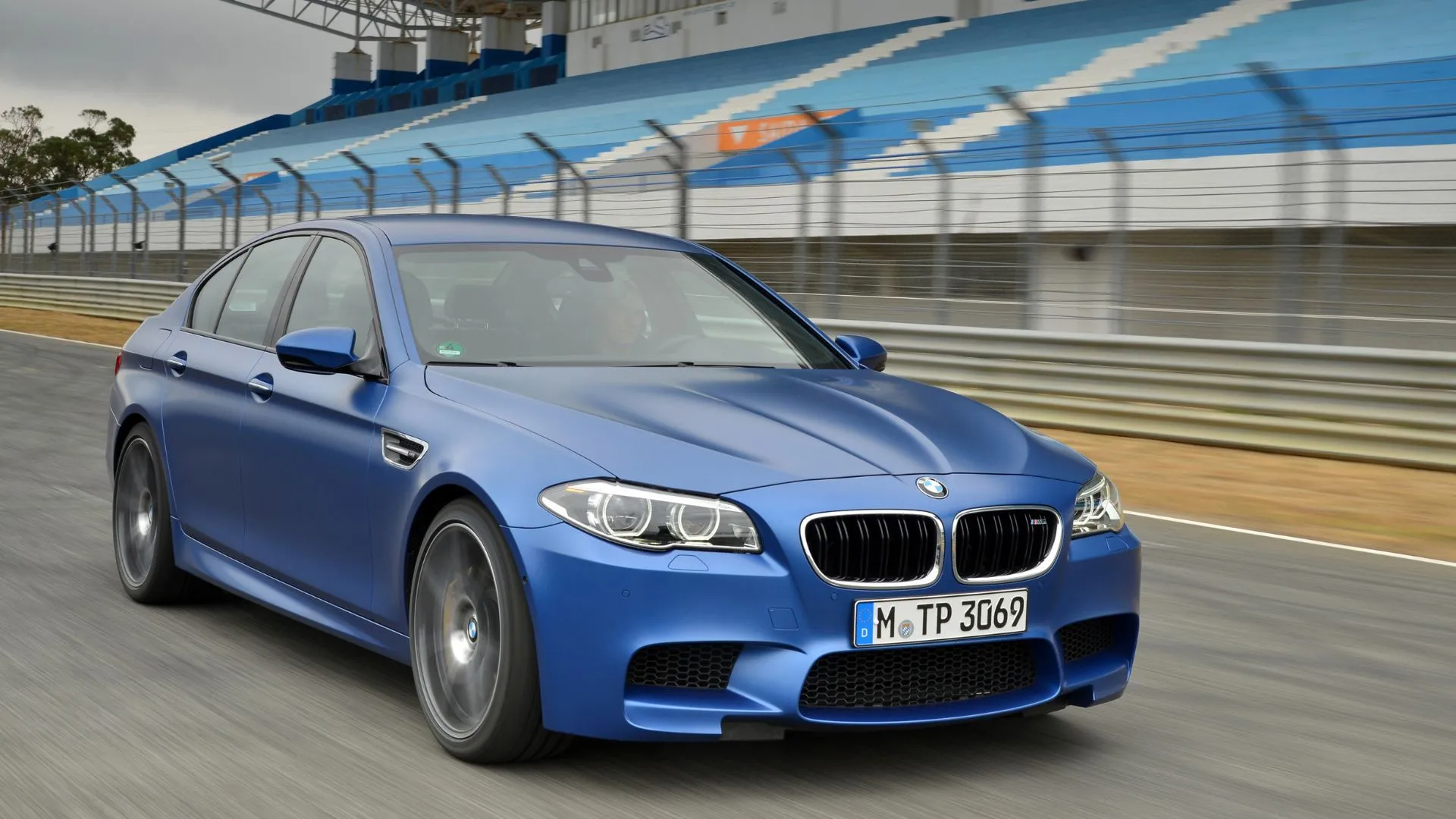 BMW M5 2015 màu xanh dương chạy trên đường đua