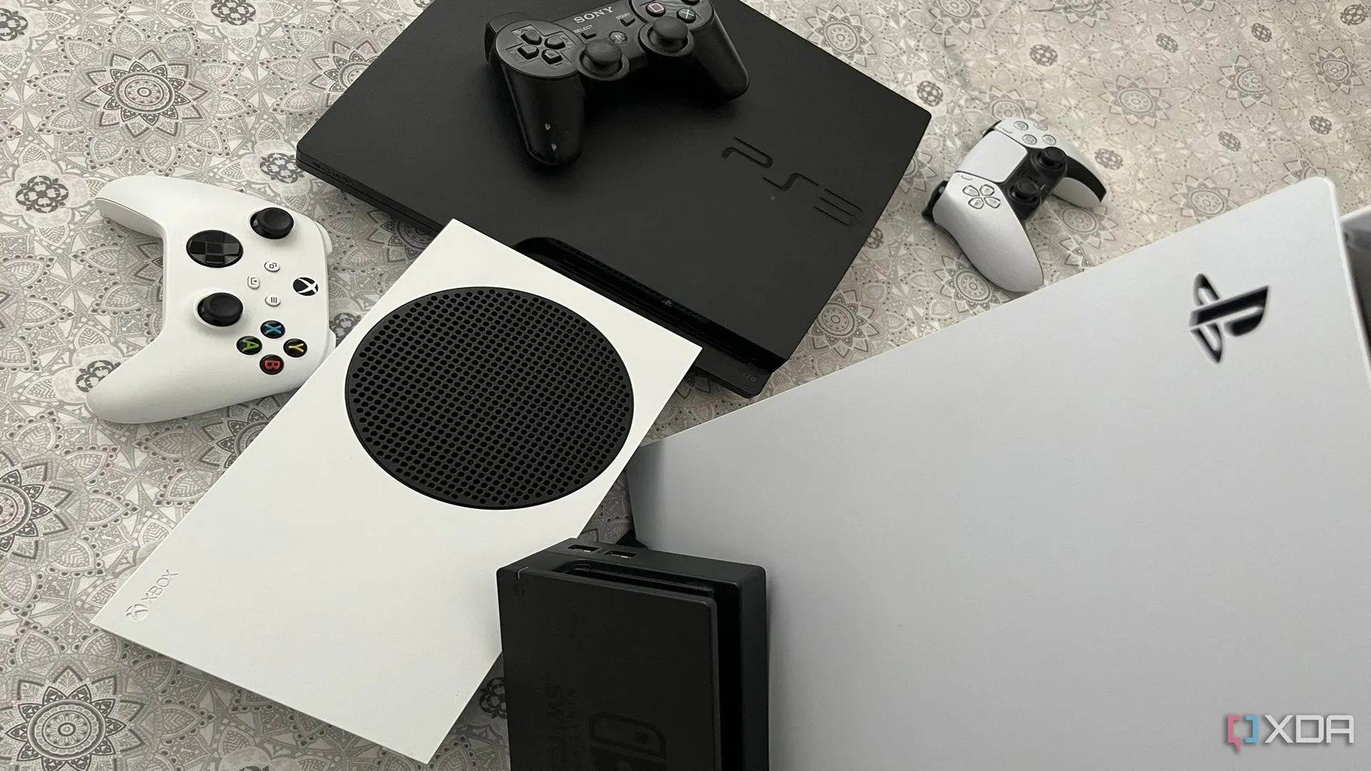 Bộ sưu tập các console game: PlayStation 5, Xbox Series X, dock Nintendo Switch và PlayStation 3 thể hiện sự đa dạng nền tảng
