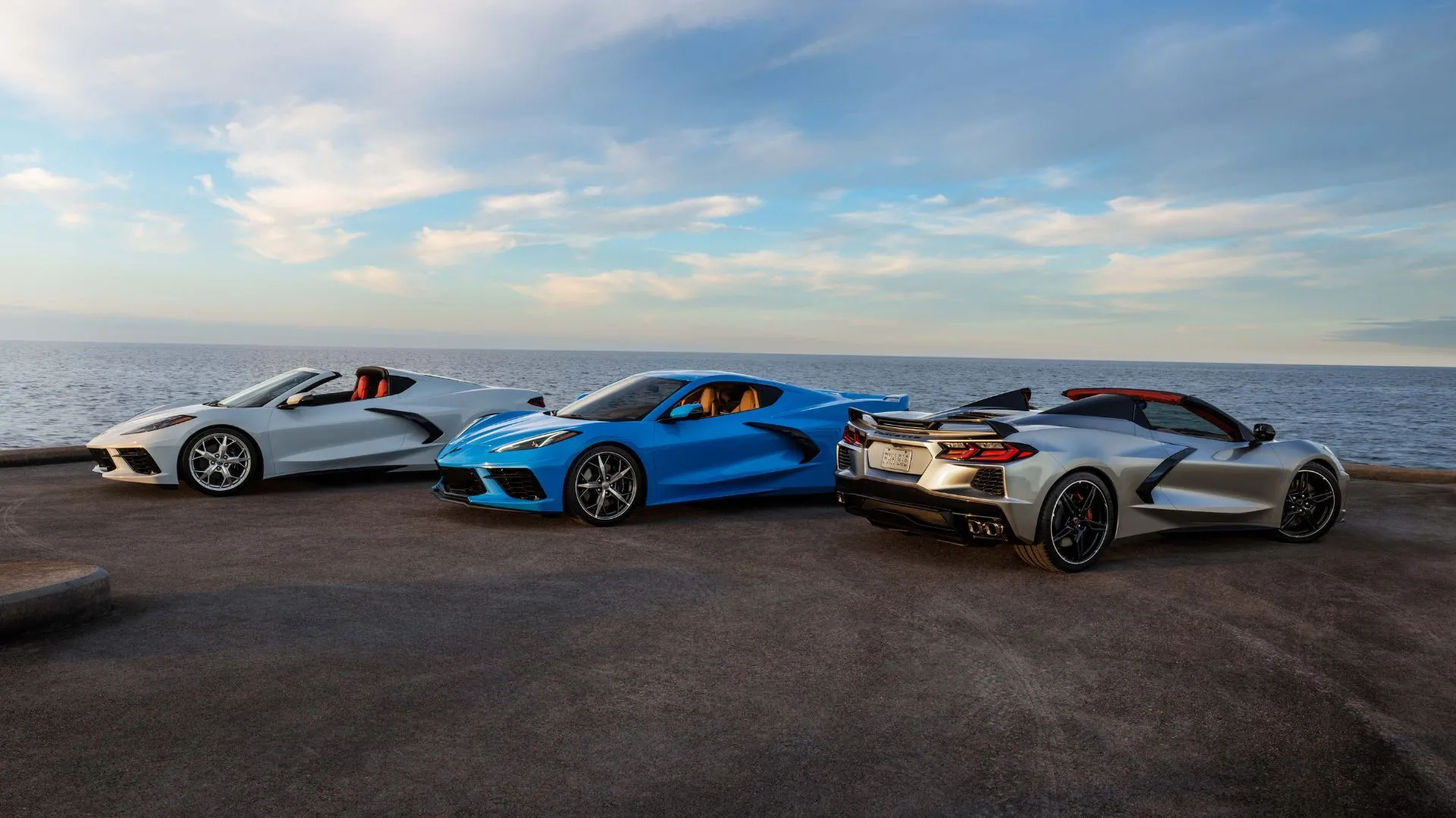 Các biến thể coupe và mui trần của Chevrolet Corvette Stingray 2021 đỗ cạnh nhau với cảnh biển phía sau, tôn vinh thiết kế thể thao và sang trọng.