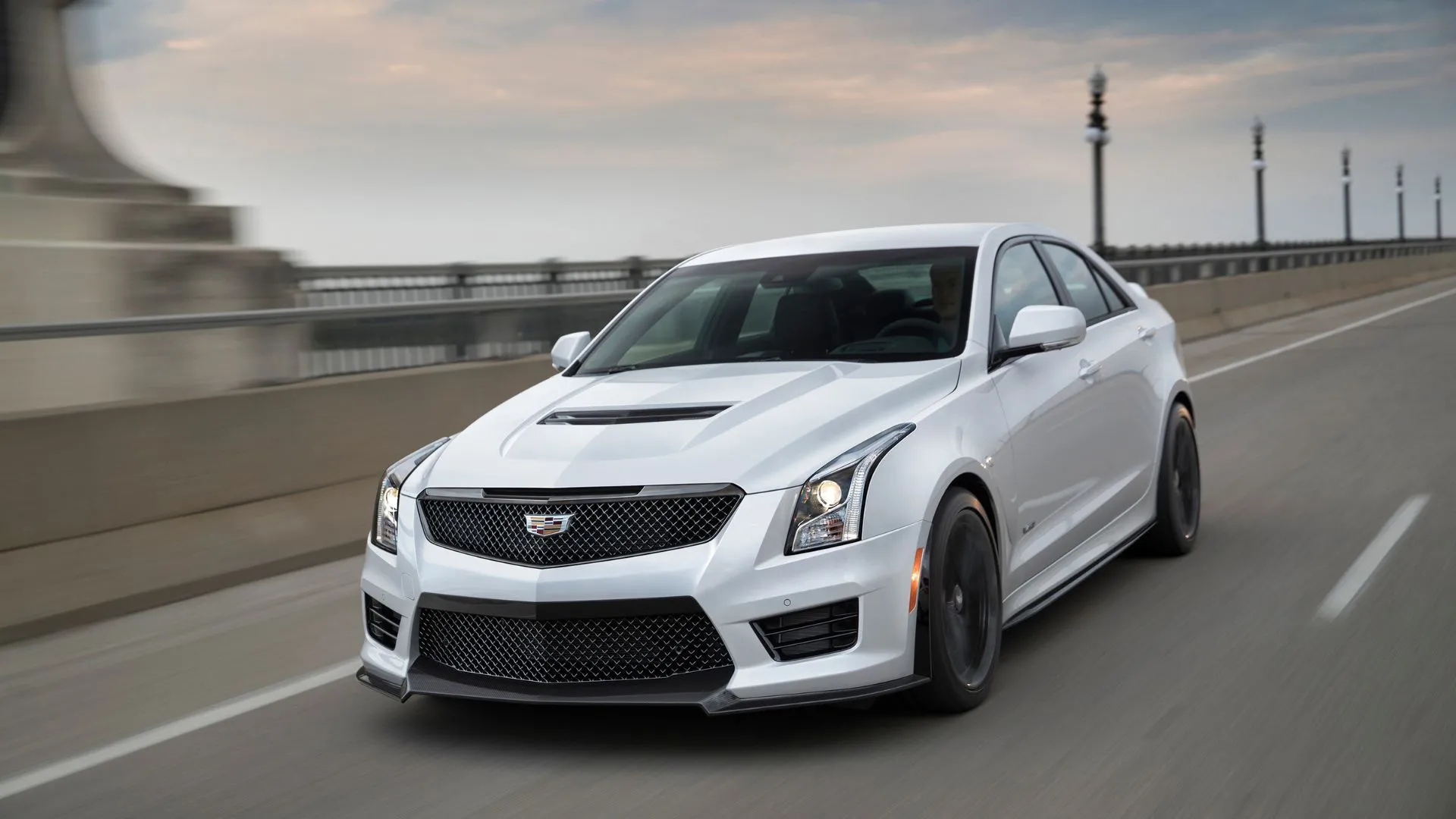 Cadillac ATS-V Sedan màu trắng đời 2018 đang chạy trên đường cao tốc, mẫu sedan hiệu suất cao với động cơ V6 tăng áp kép mạnh mẽ.