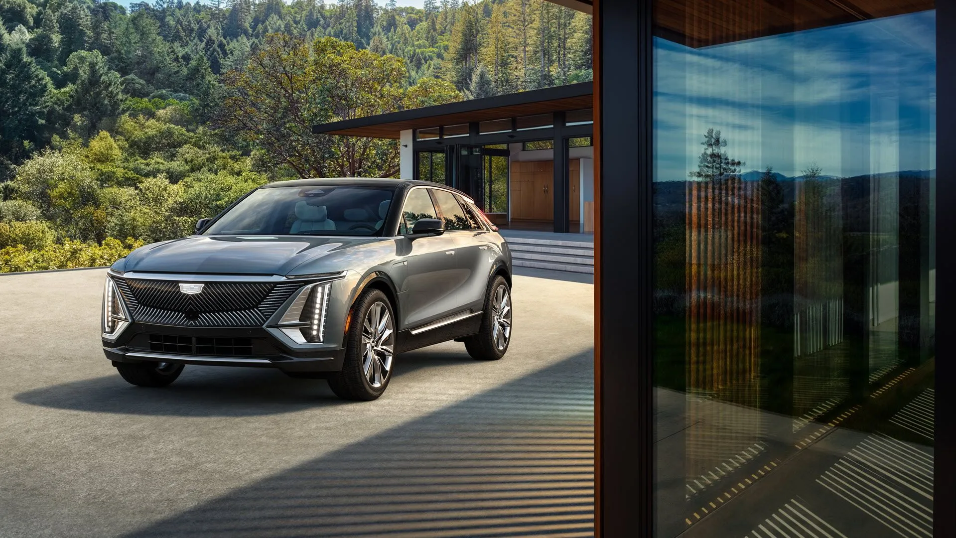 Cadillac Lyriq màu xám bạc sang trọng đậu trước nhà, biểu tượng xe điện cao cấp
