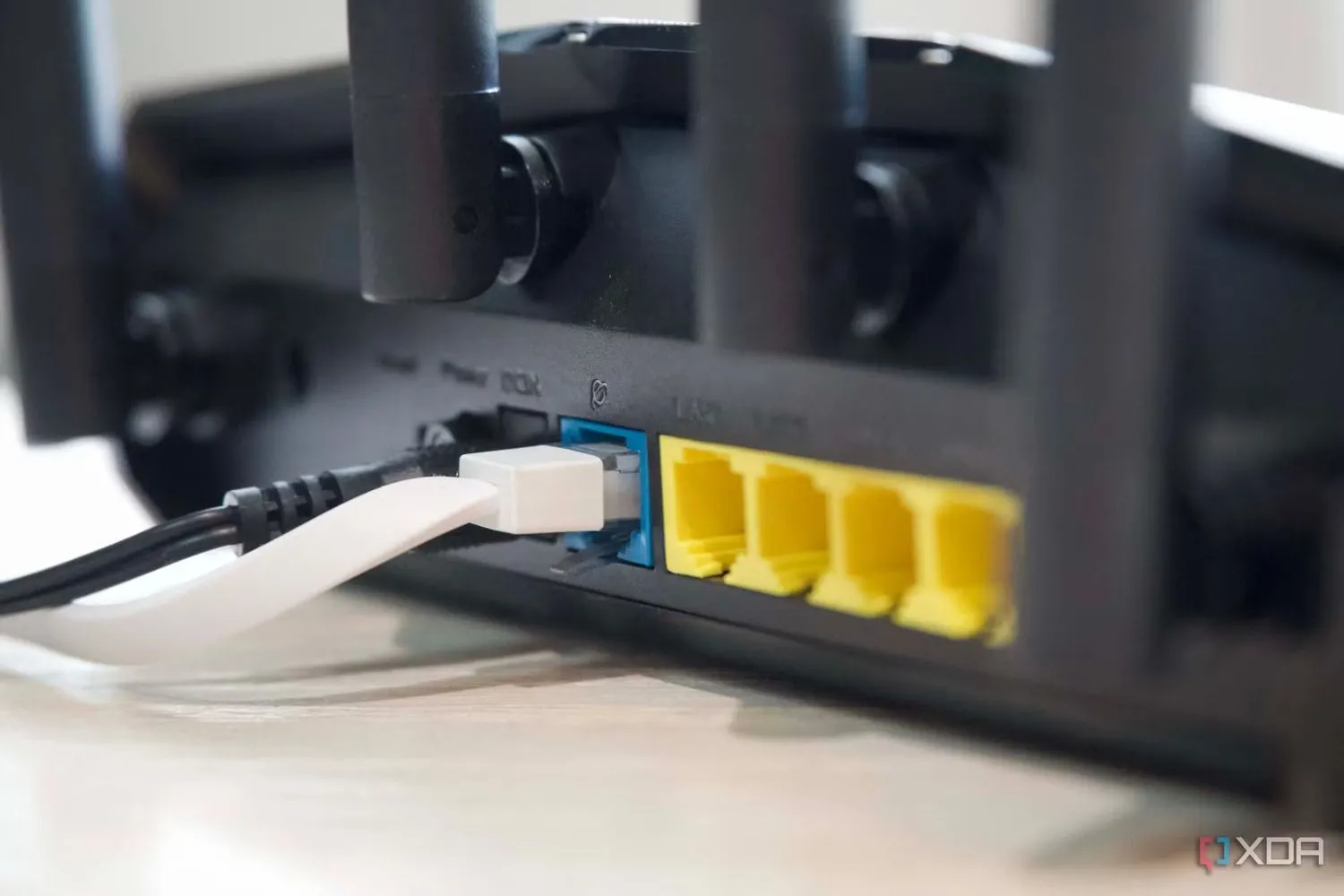 Cận cảnh các cổng Ethernet và ăng-ten của router Asus RT-AX57, minh họa sự phổ biến của kết nối có dây trước khi Wi-Fi 7 thay đổi cuộc chơi