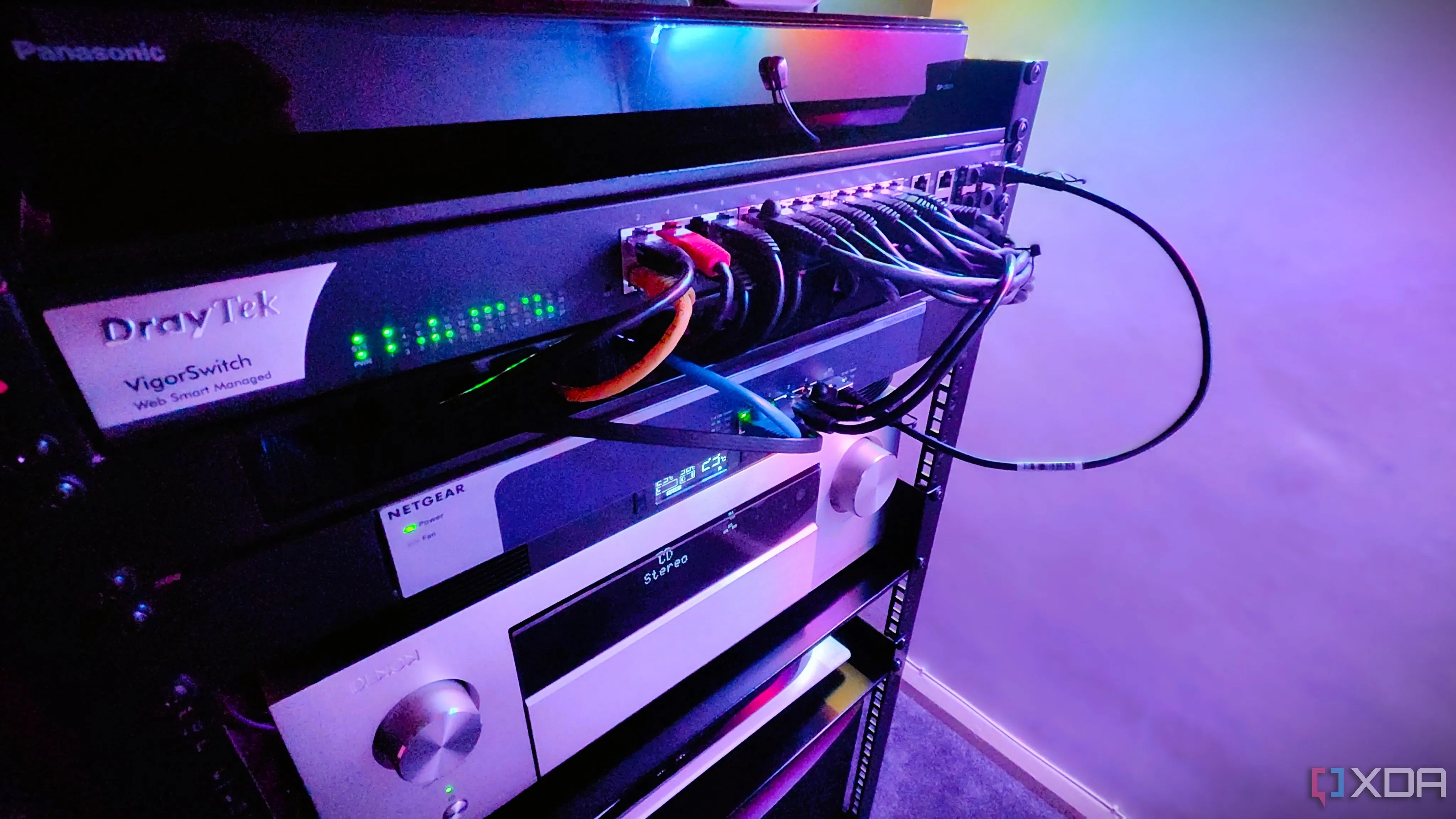 Cận cảnh một tủ rack mạng với nhiều switch và thiết bị A/V, minh họa cho việc sử dụng thiết bị mạng chuyên dụng