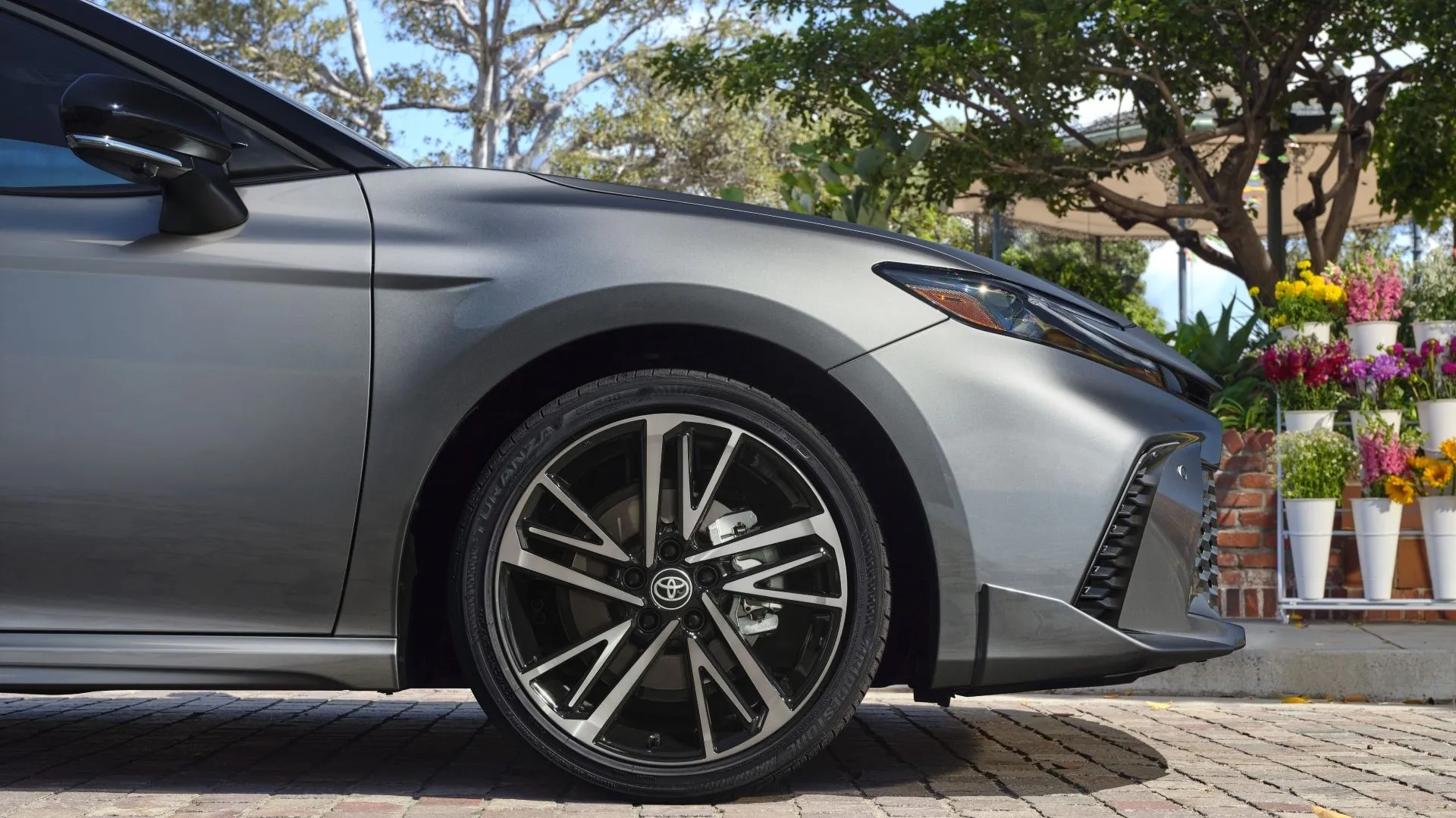 Cận cảnh phần đầu xe Toyota Camry 2025, cho thấy thiết kế đèn pha và lưới tản nhiệt mới