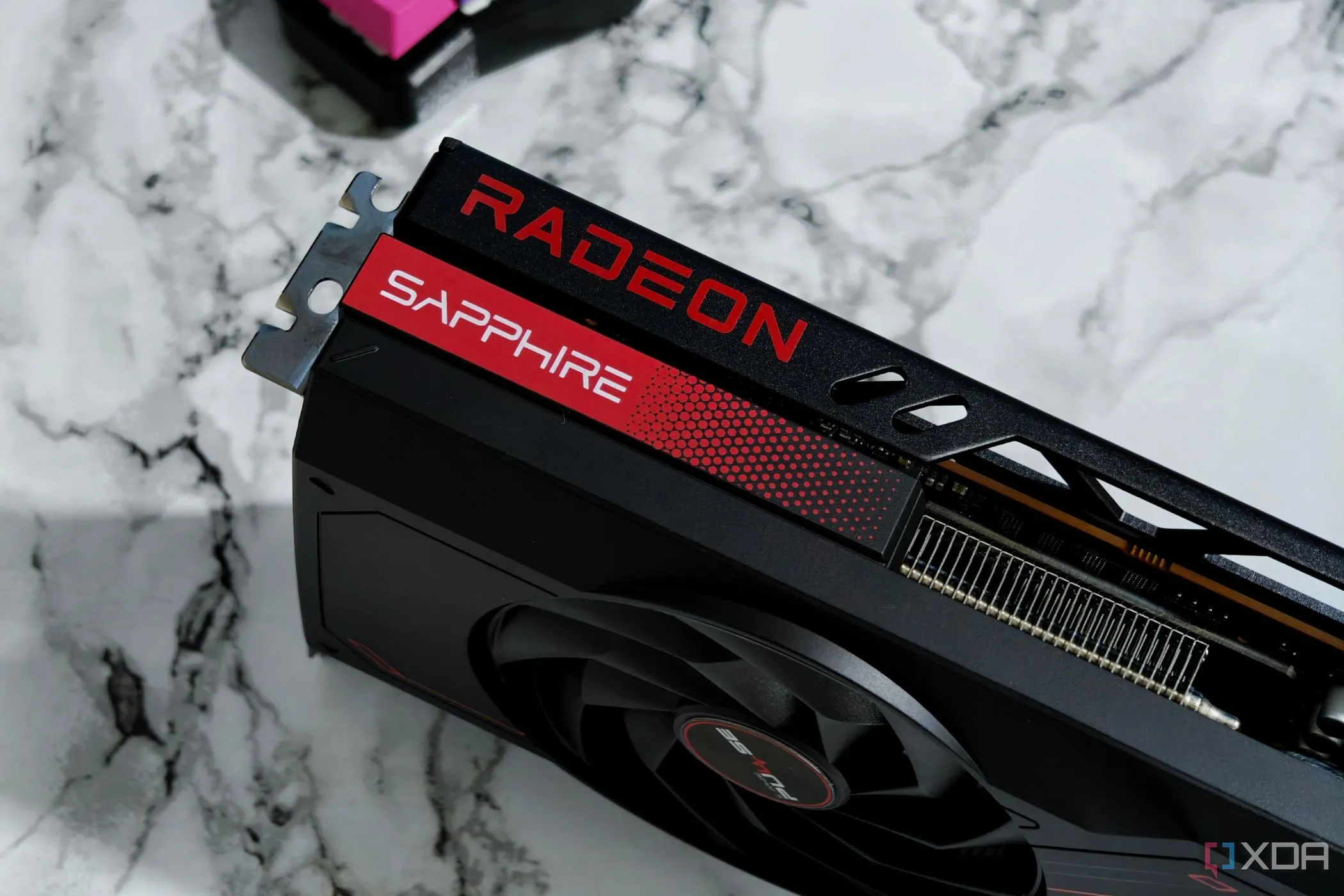 Card đồ họa AMD Radeon RX 7700 XT đặt trên bàn làm việc, tượng trưng cho lựa chọn phần cứng GPU.