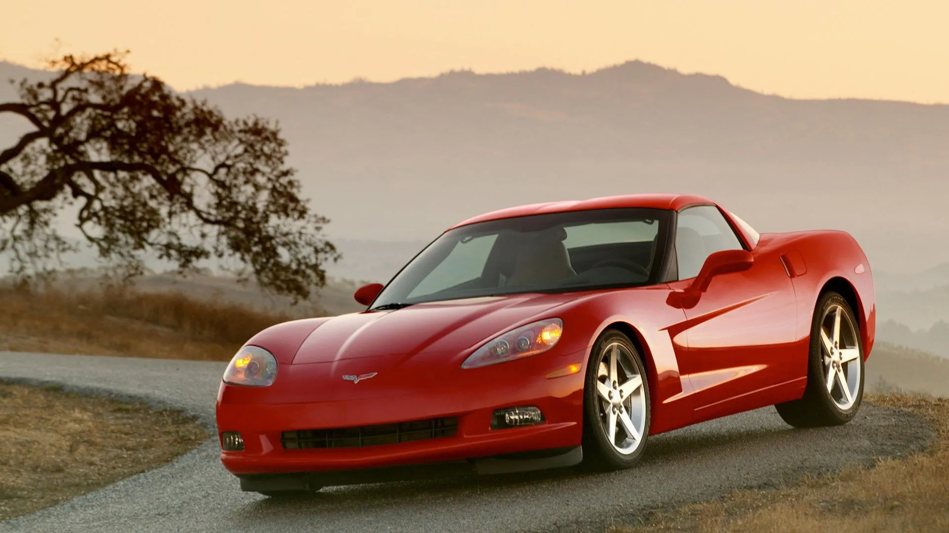 Chevrolet Corvette 2005 màu đỏ tươi đậu trên góc đường, góc nhìn 3/4 từ phía trước