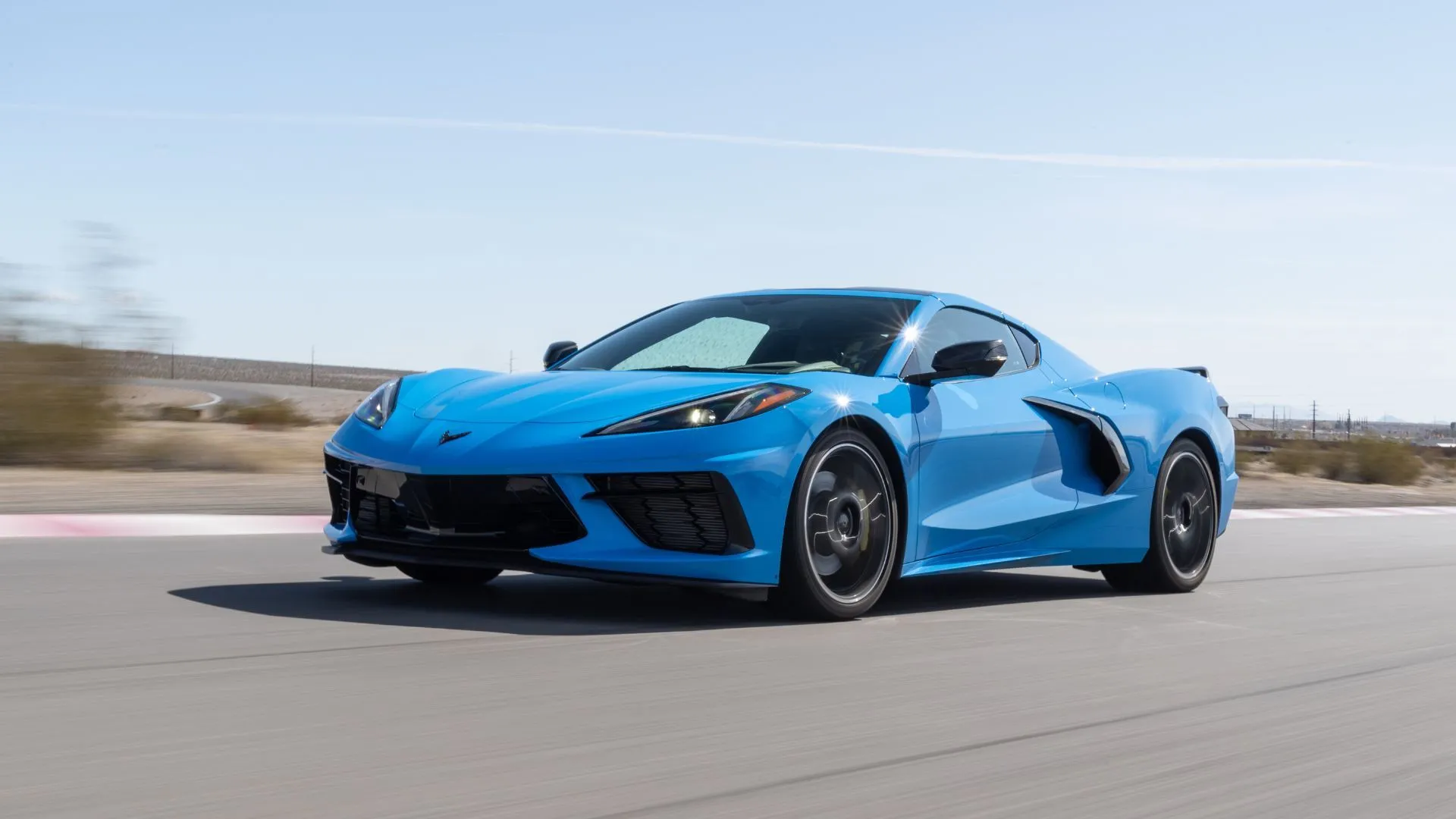 Chevrolet Corvette Stingray C8 2025 màu xanh dương đang chạy trên đường nông thôn