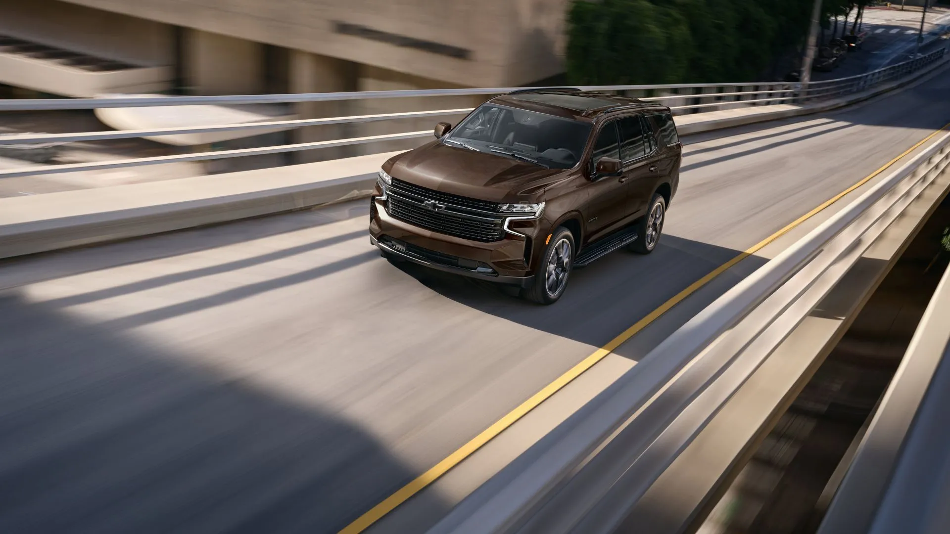 Chevrolet Tahoe 2023 màu nâu đang di chuyển trên đường cao tốc, nổi bật là SUV cũ đa dụng và mạnh mẽ cho gia đình.