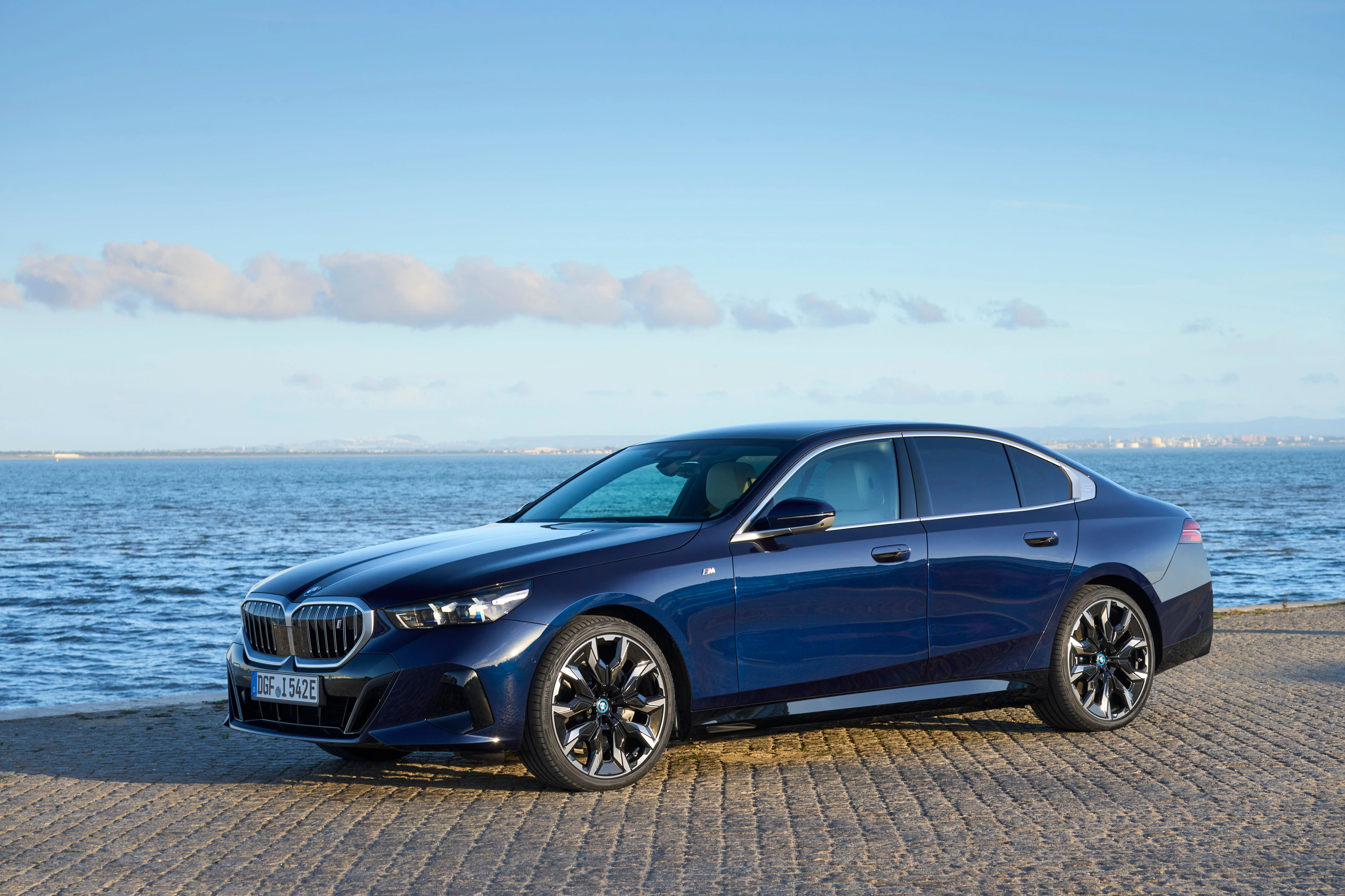 Chiếc BMW i5 M60 xDrive màu đen đang đỗ trong một khung cảnh đô thị hiện đại.
