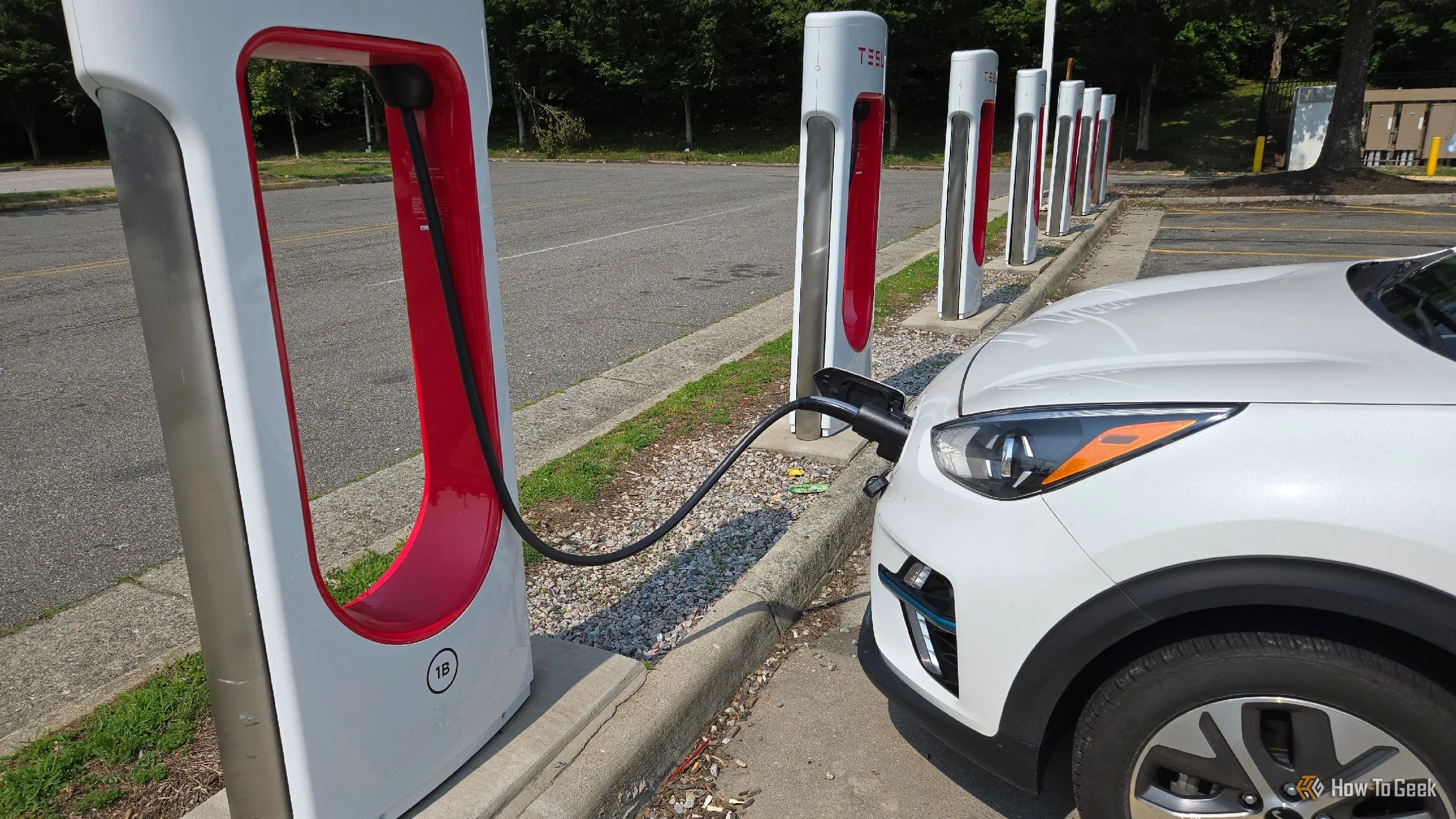 Chiếc Kia Niro EV đang sạc tại trụ Tesla Supercharger thông qua adapter, tăng gấp đôi khả năng tiếp cận trạm sạc.
