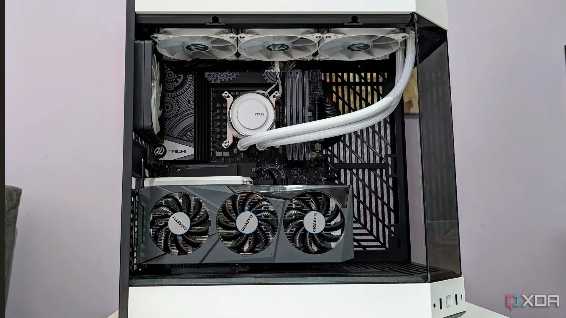 Dàn máy tính chơi game trong vỏ case màu trắng đã tháo mặt bên, với một ống dẫn tự chế bằng bìa cứng nối từ lỗ thông gió của điều hòa vào bên trong, minh họa cách làm mát bằng điều hòa.