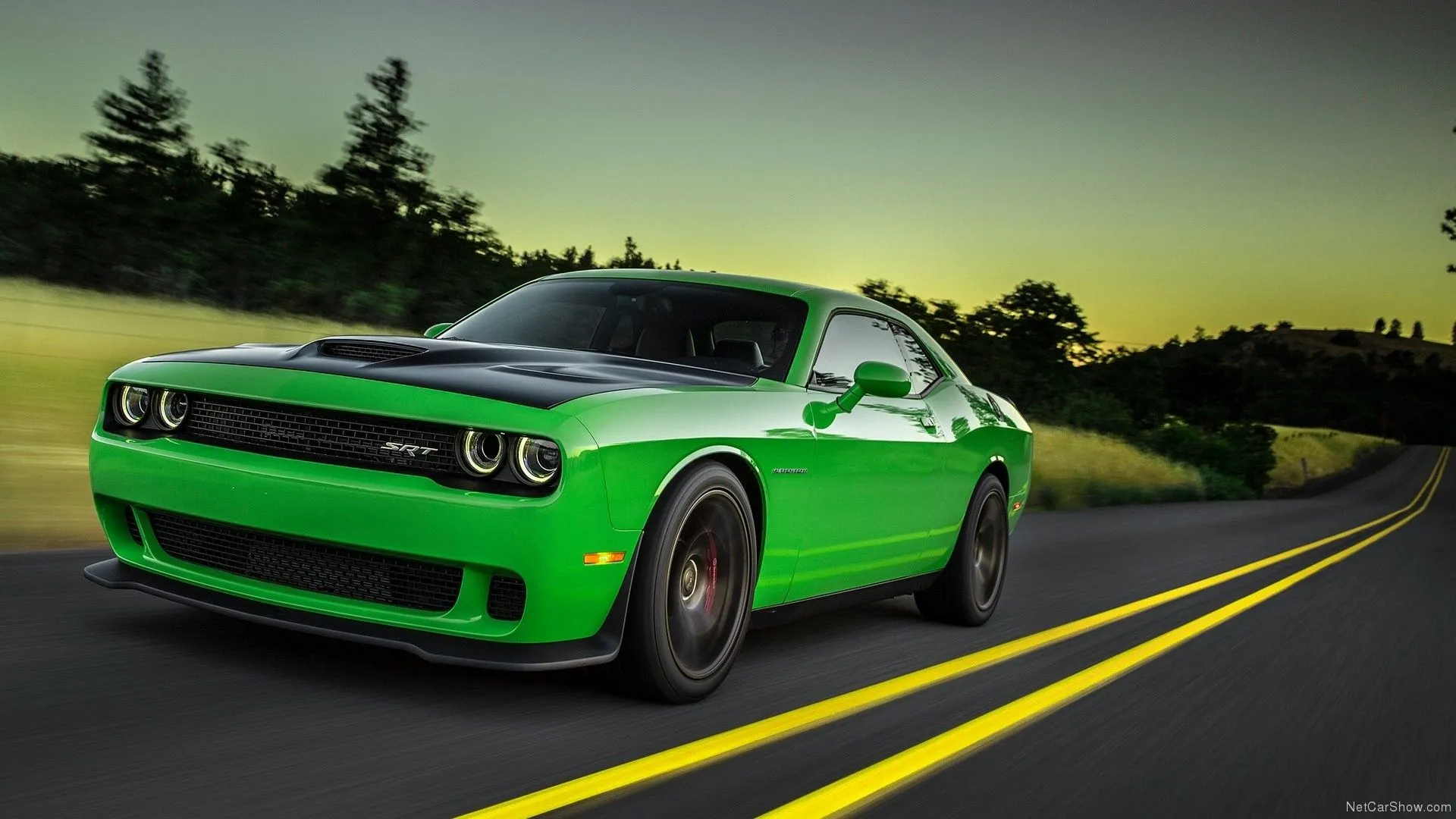 Dodge Challenger SRT Hellcat 2015 màu xanh lá cây đậm đang tăng tốc mạnh mẽ, góc nhìn 3/4 từ phía trước, thể hiện sức mạnh vượt trội