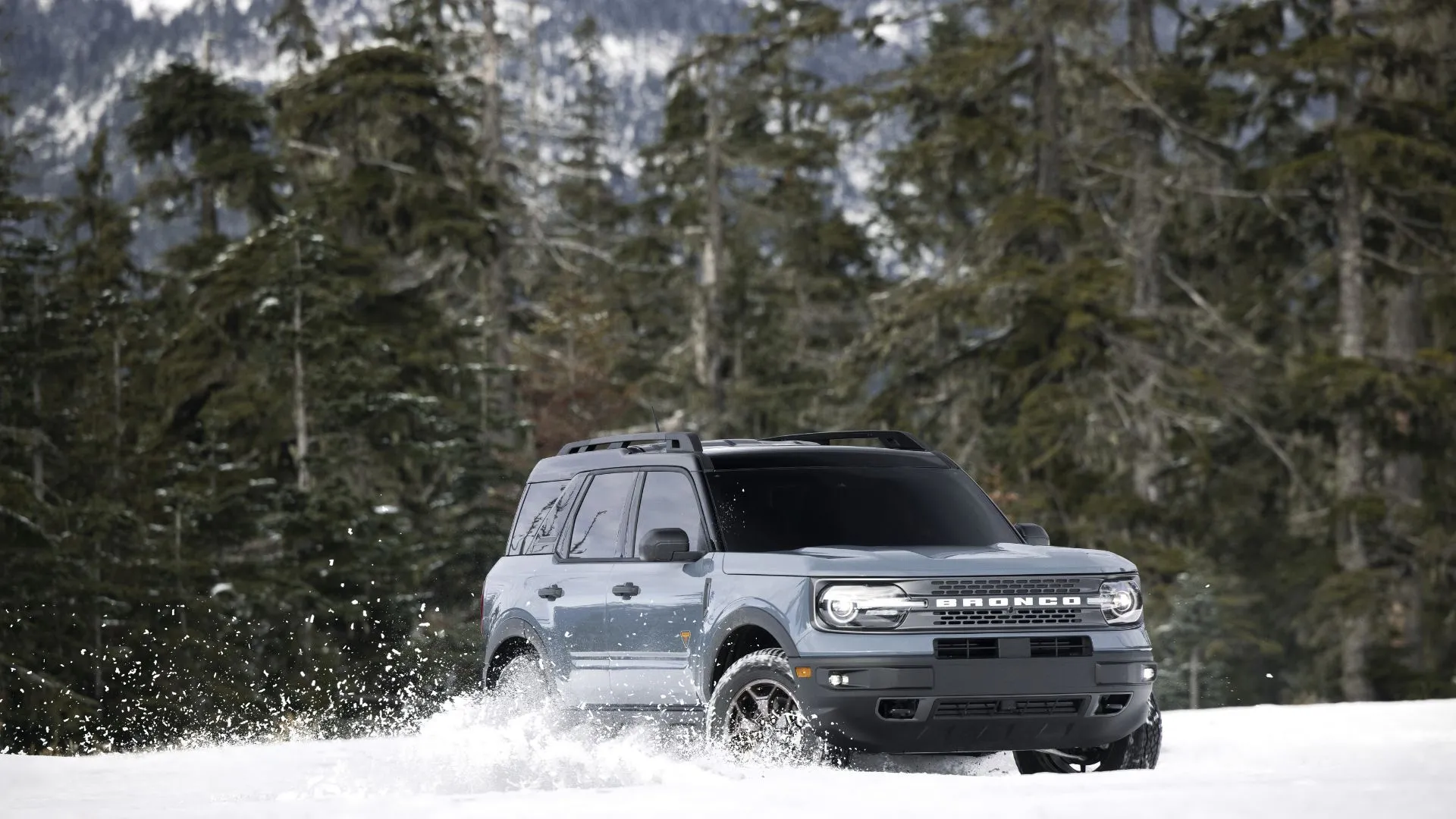 Ford Bronco Sport 2022 màu xám đang vượt địa hình trên tuyết