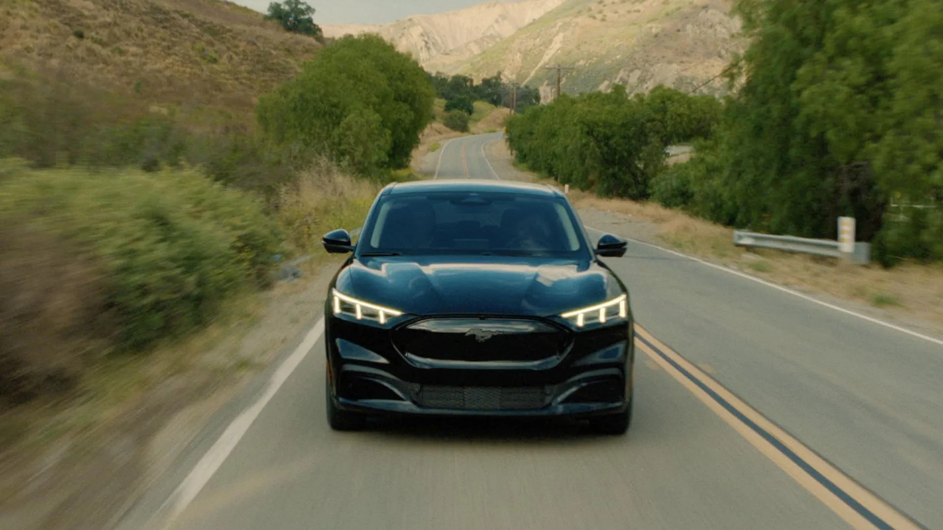 Ford Mustang Mach-E Premium màu đen đang lái trên đường nông thôn
