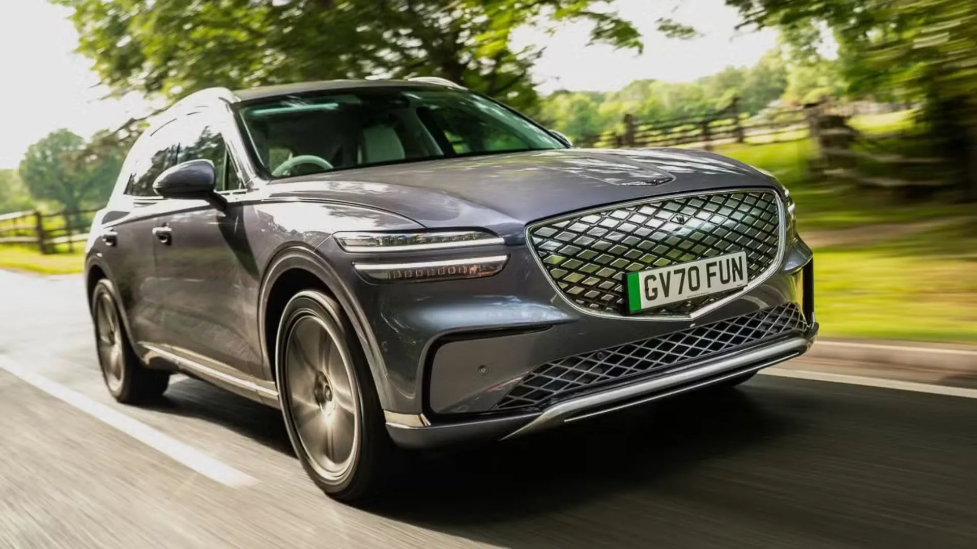 Genesis Electrified GV70 2026 màu xám đang chạy trên đường quê