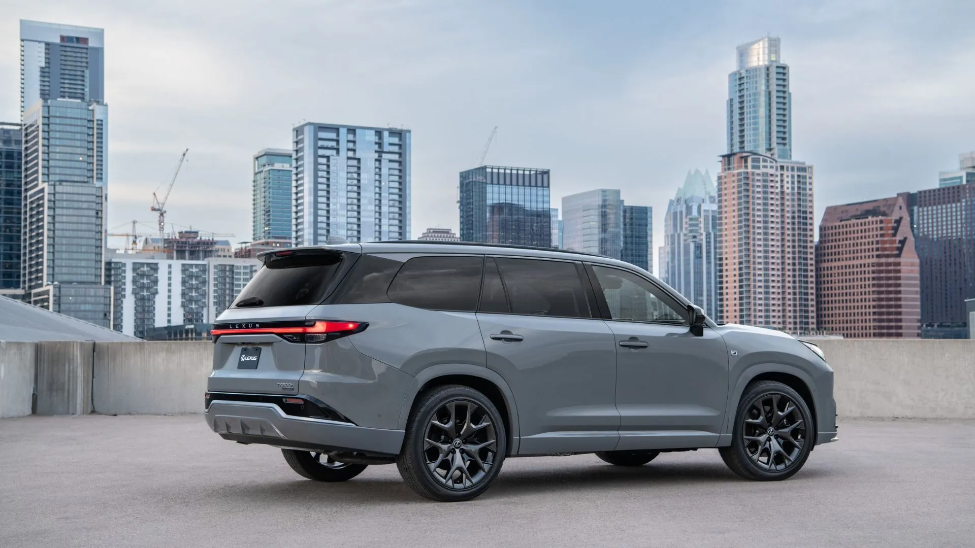 Góc 3/4 phía sau xe Lexus TX 500h FSPORT Luxury 2025 màu bạc đậu trên sân thượng