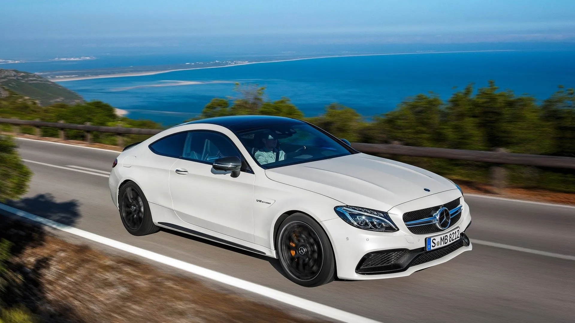 Góc 3/4 phía trước của Mercedes-AMG C63 Coupe 2017 màu xám mạnh mẽ đang di chuyển
