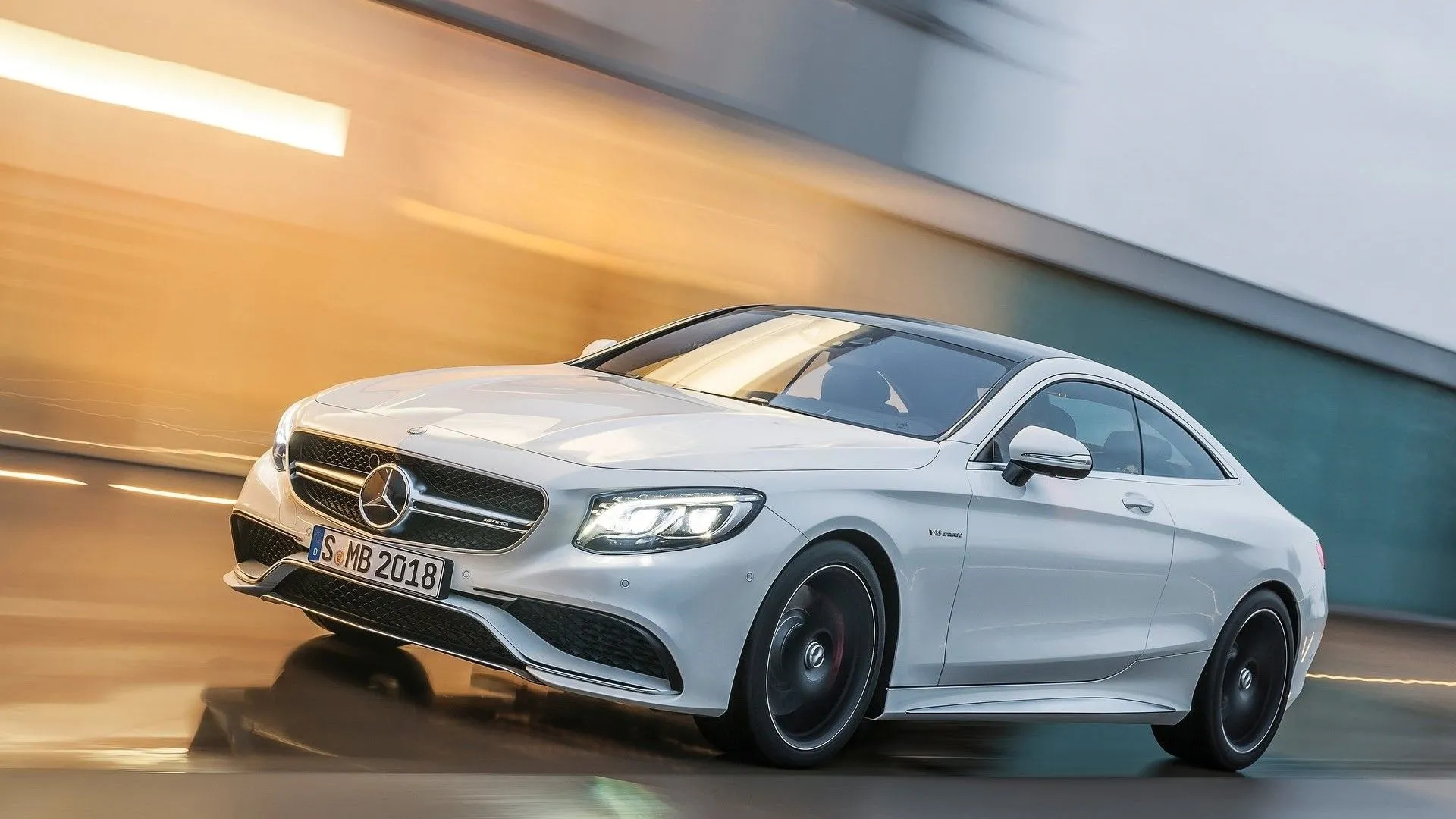 Góc 3/4 phía trước của Mercedes-AMG S63 Coupe 2015 màu bạc đang lao vun vút trên đường cao tốc