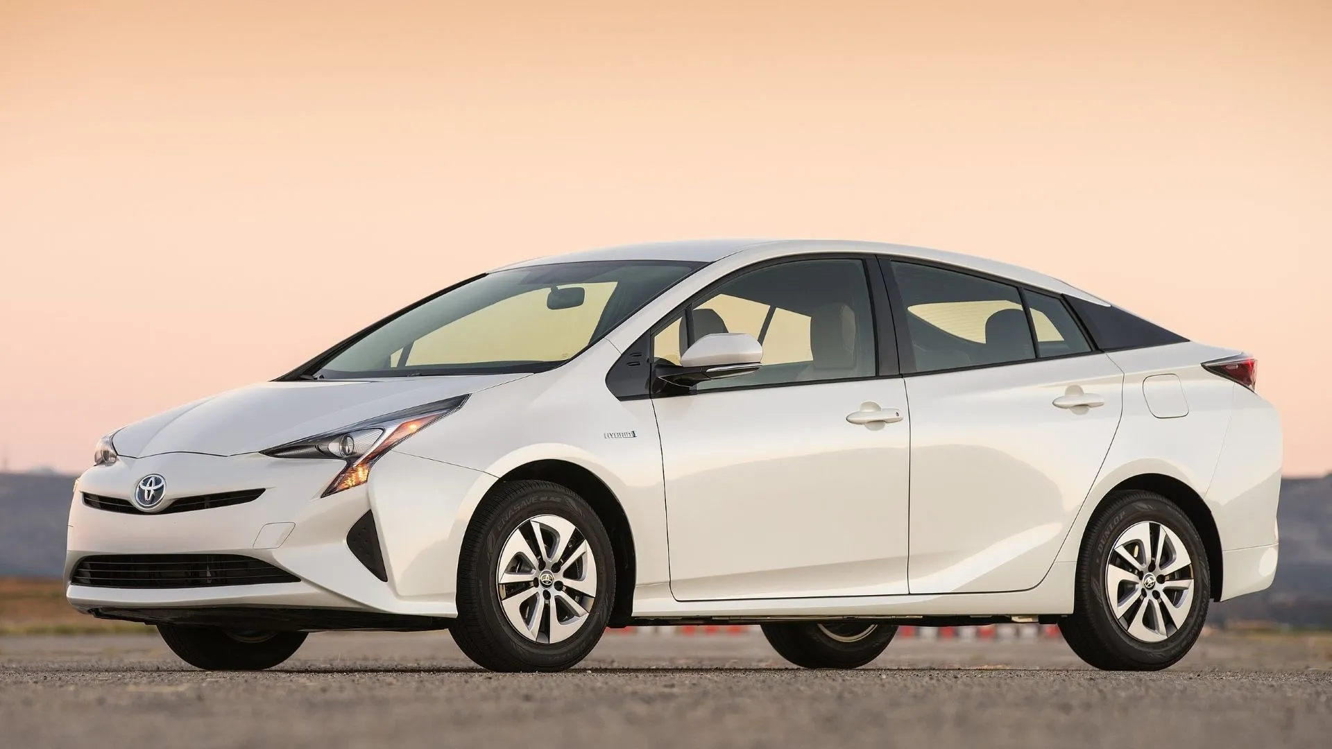 Góc 3/4 phía trước của Toyota Prius 2016 màu xám bạc, với thiết kế khí động học đặc trưng.
