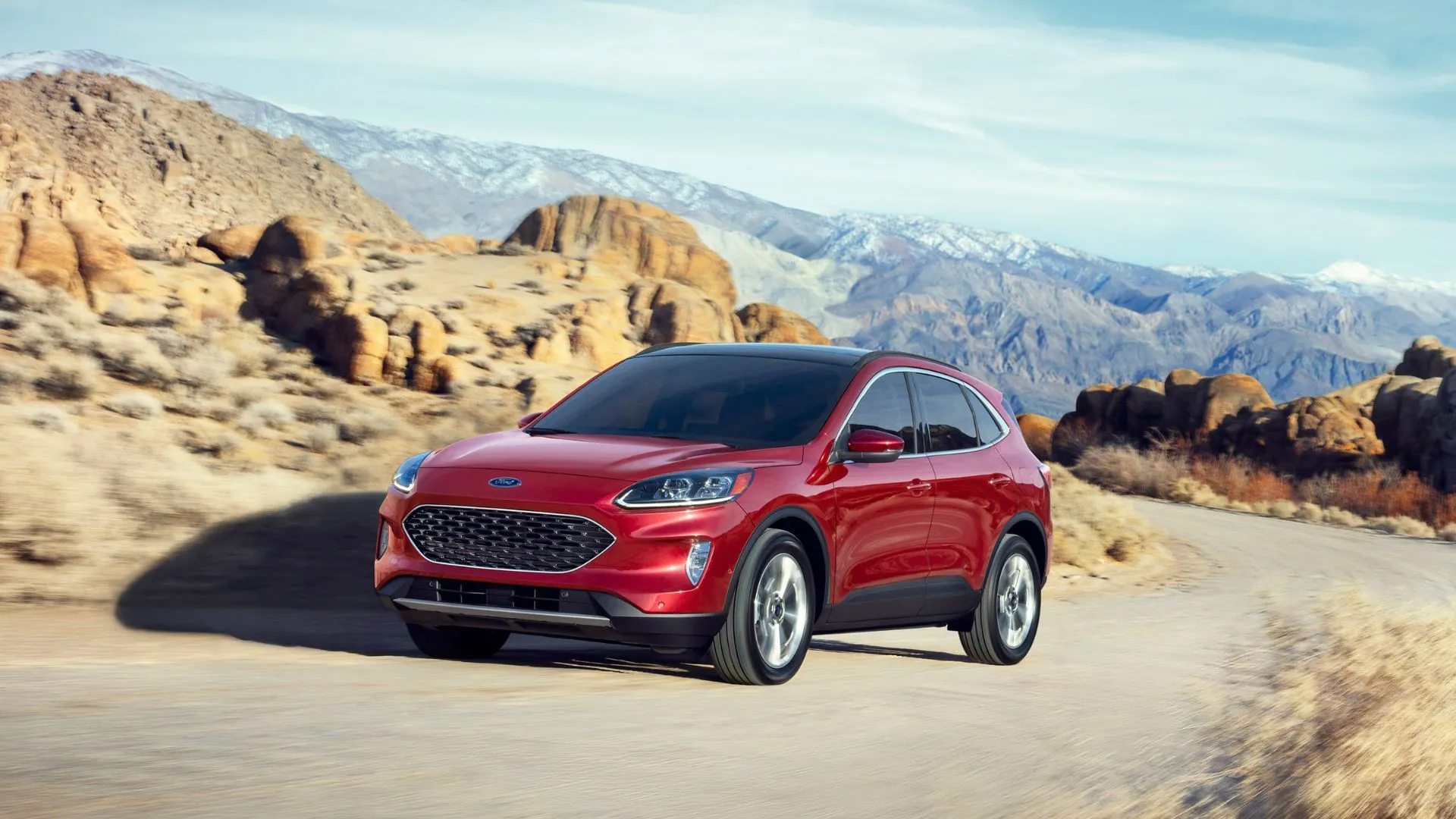 Góc ba phần tư phía trước của Ford Escape Hybrid 2020 màu đỏ đang lái lên một con đường đèo quanh co, thể hiện sự linh hoạt và khả năng di chuyển.