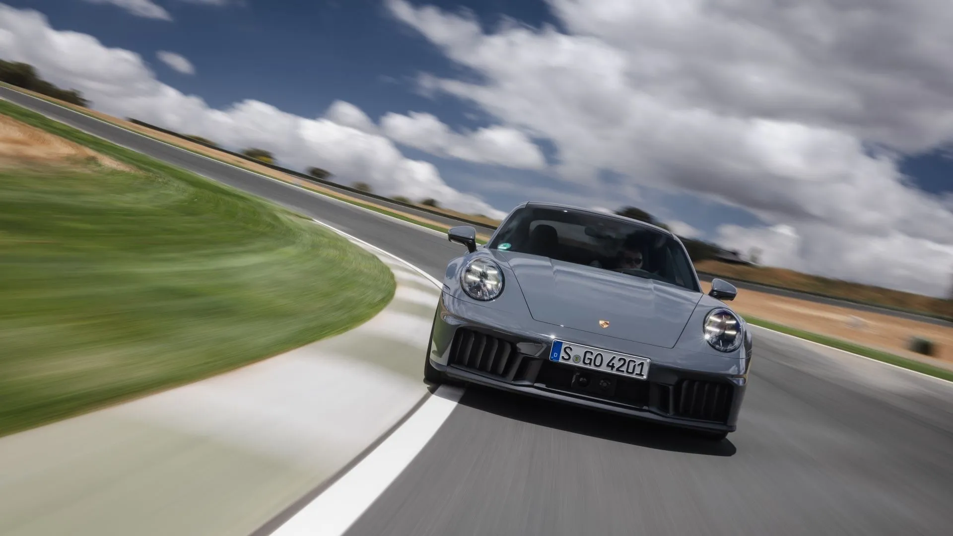 Góc trực diện của Porsche 911 Carrera GTS 2025 đang di chuyển, minh họa hiệu suất vượt trội và thiết kế thể thao đẳng cấp của mẫu xe Đức.