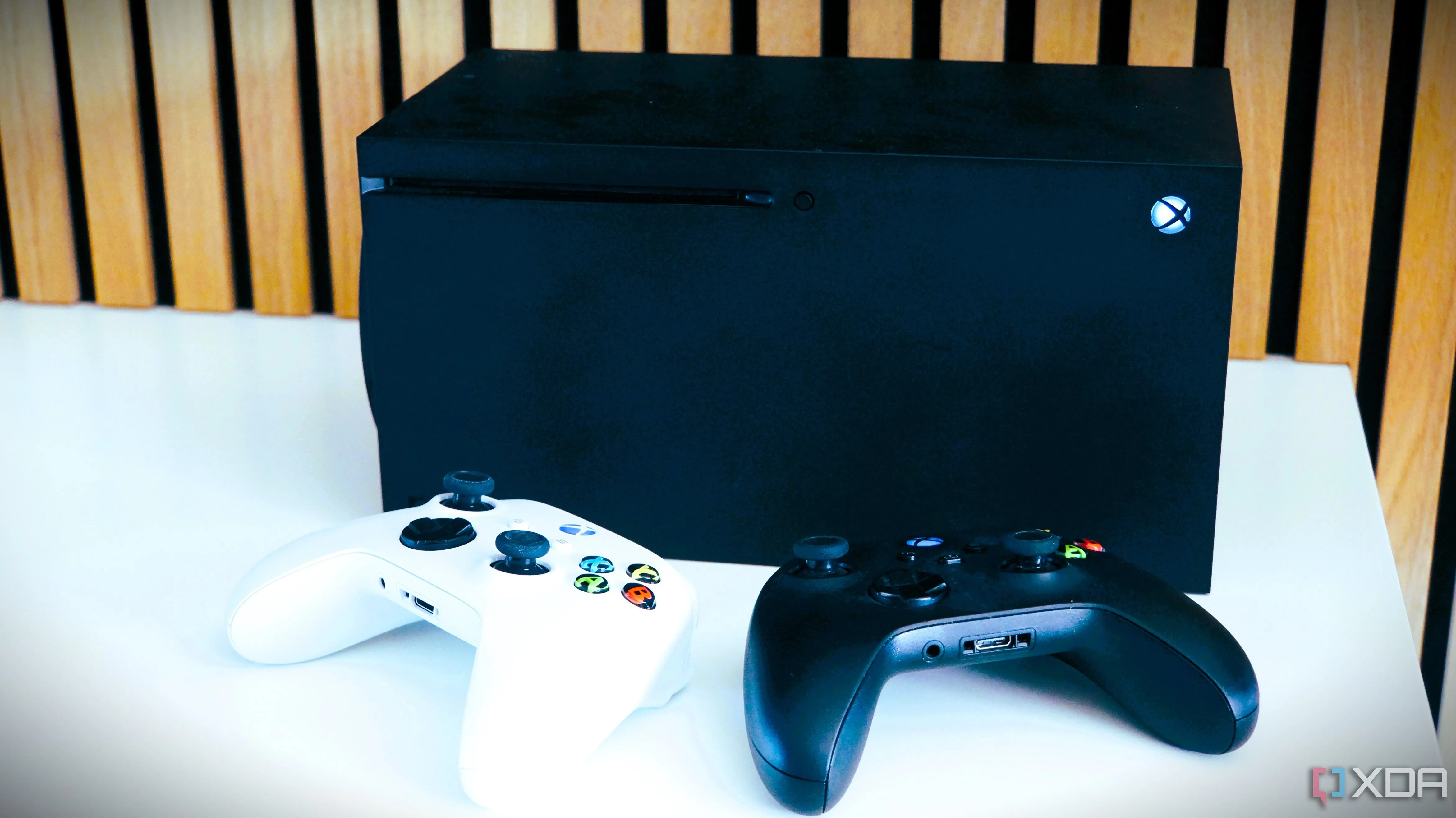 Hai tay cầm Xbox trước máy Xbox Series X, minh họa việc tăng giá phần cứng và game