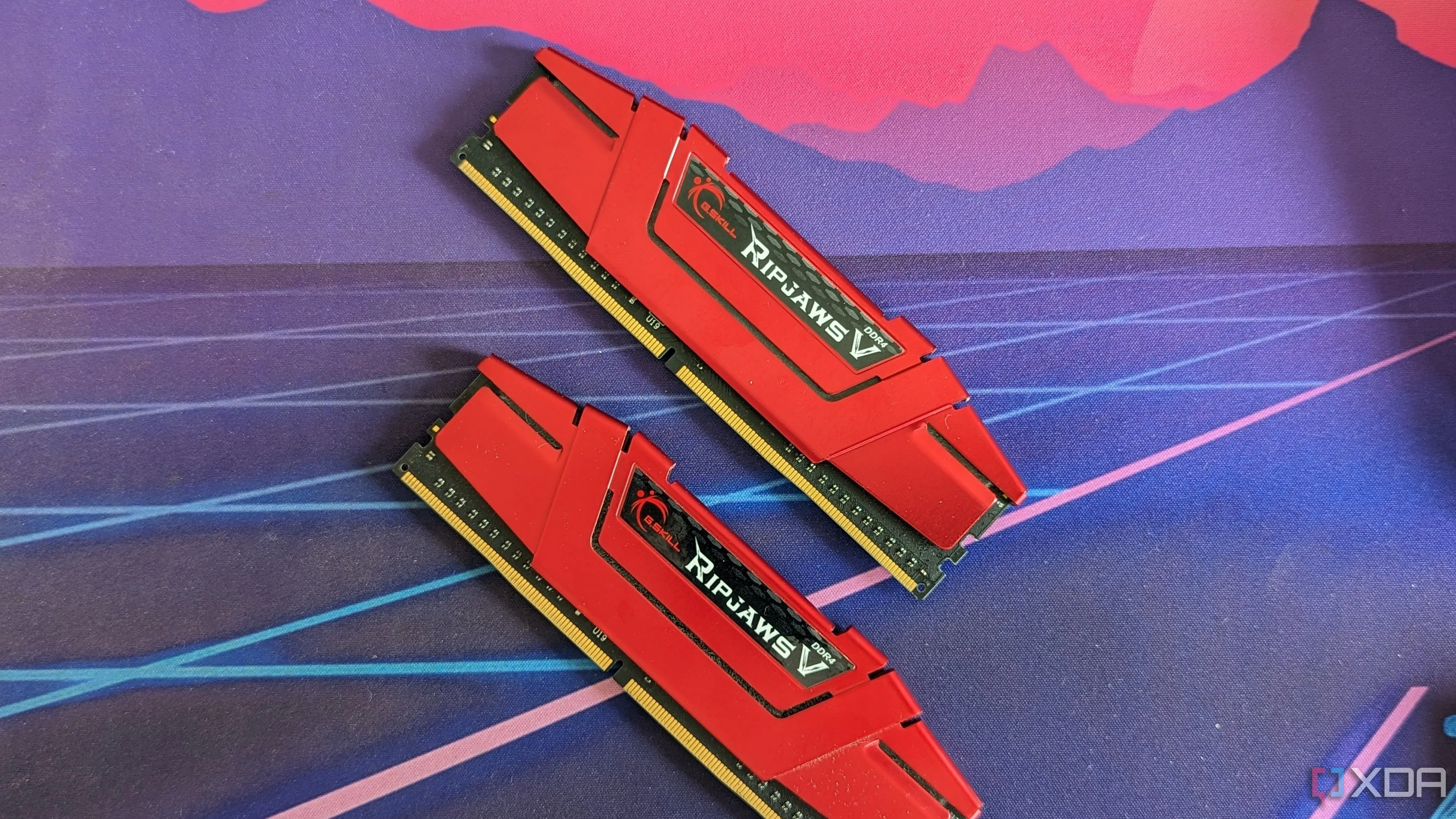 Hai thanh RAM G.Skill Ripjaws DDR4 màu đỏ đặt trên bàn, thể hiện sự ổn định và giá trị của RAM DDR4