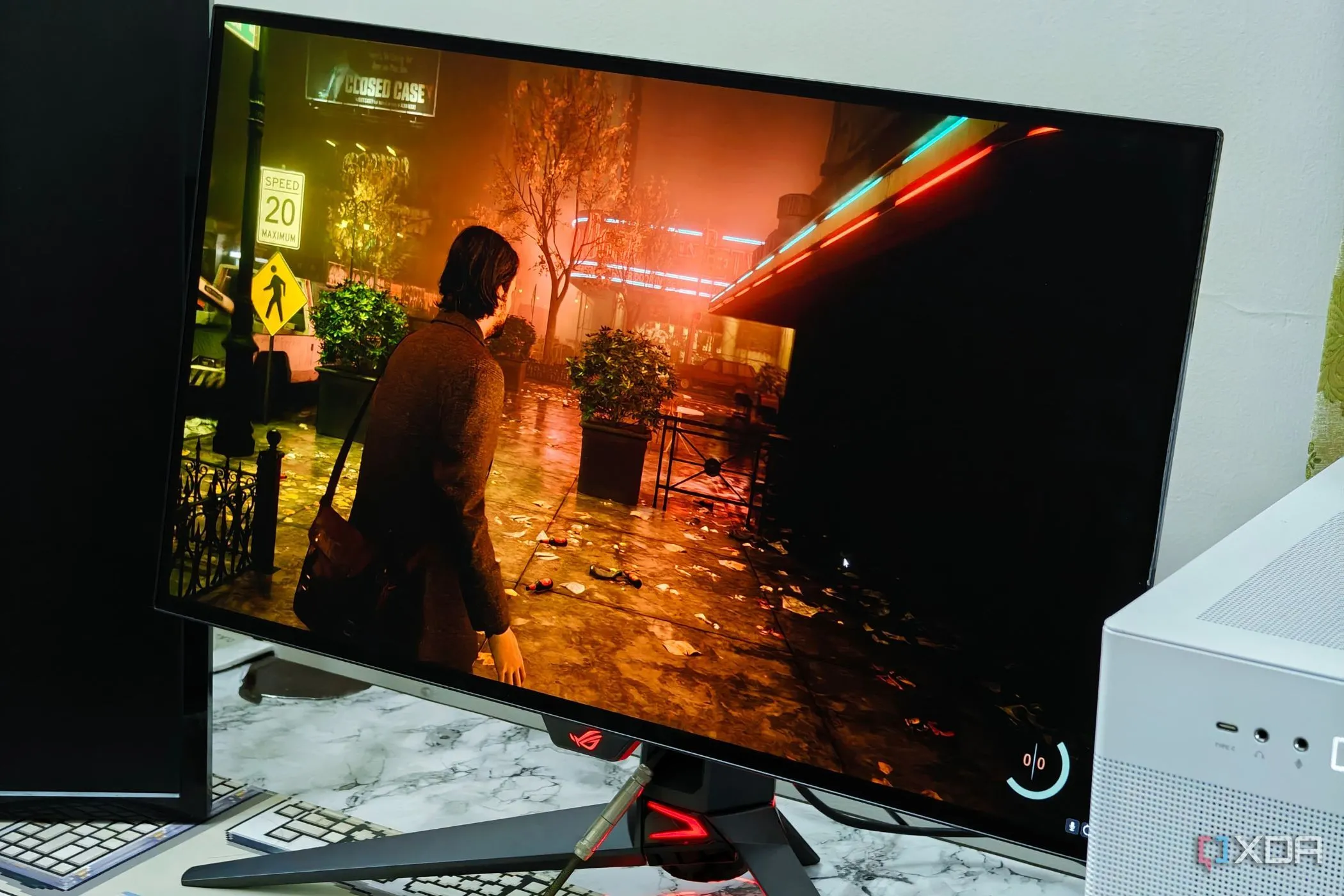 Hình ảnh game Alan Wake 2 sắc nét trên màn hình Asus ROG Swift PG27AQDM, thể hiện chất lượng hình ảnh và tần số quét cao.