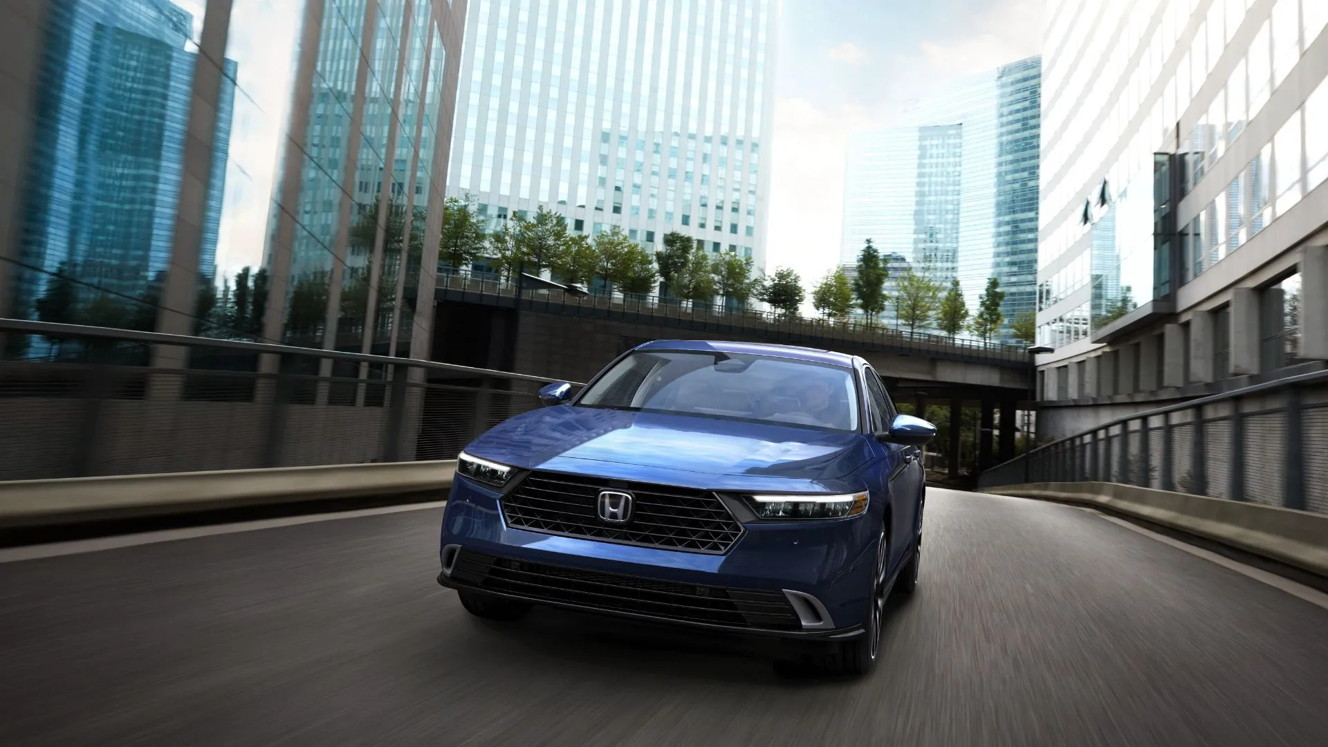 Honda Accord Touring 2023 màu xanh dương đang di chuyển trên phố, thể hiện sự sang trọng và hiện đại trong thiết kế sedan.