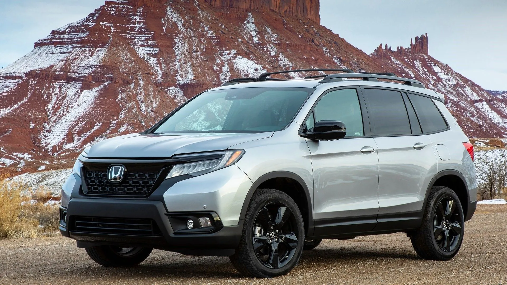 Honda Passport 2019 màu đỏ từ góc 3/4 phía trước đậu trên nền cỏ