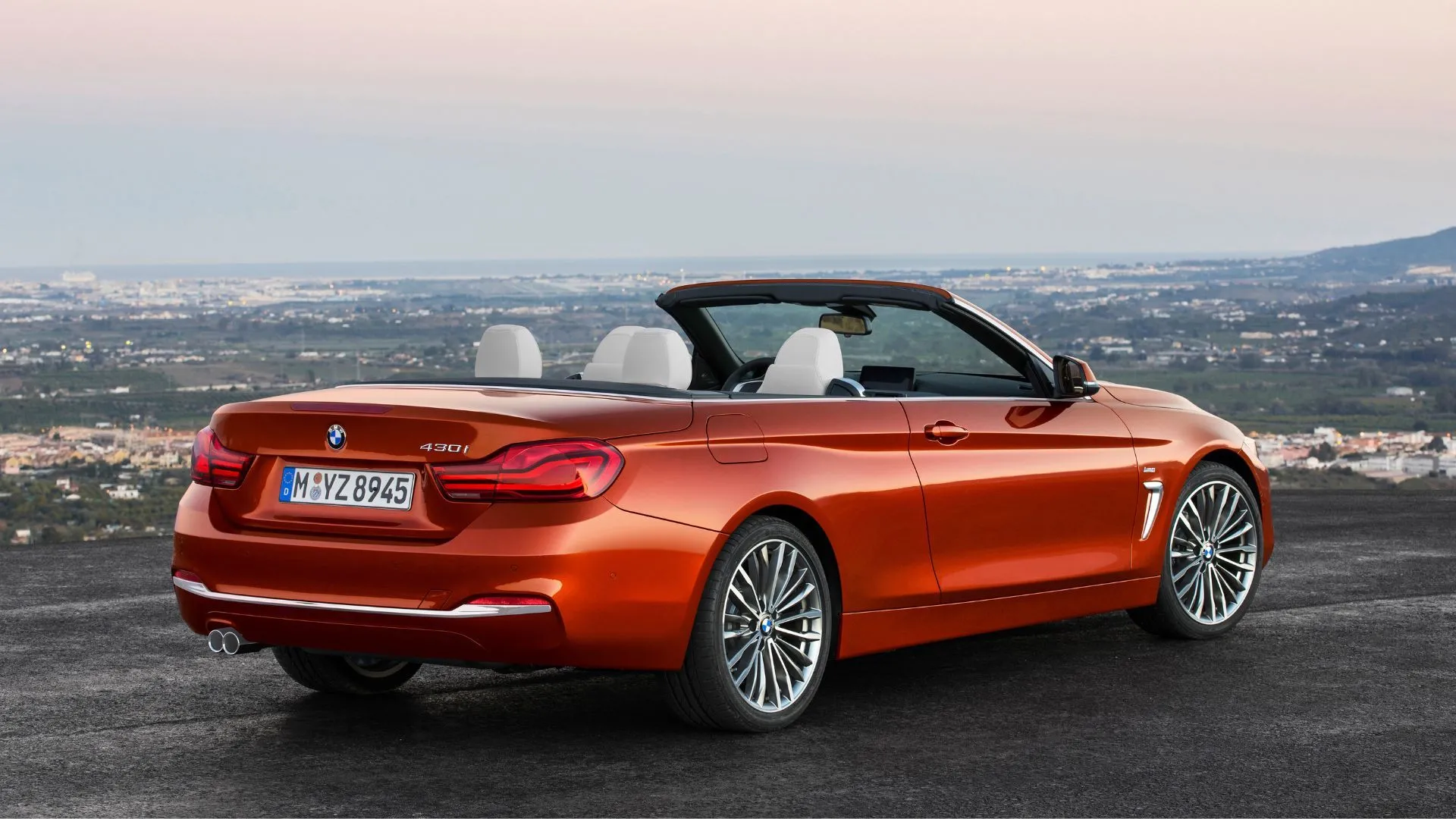 Hông sau BMW 430i Convertible 2017 màu cam với mui xe xếp gọn