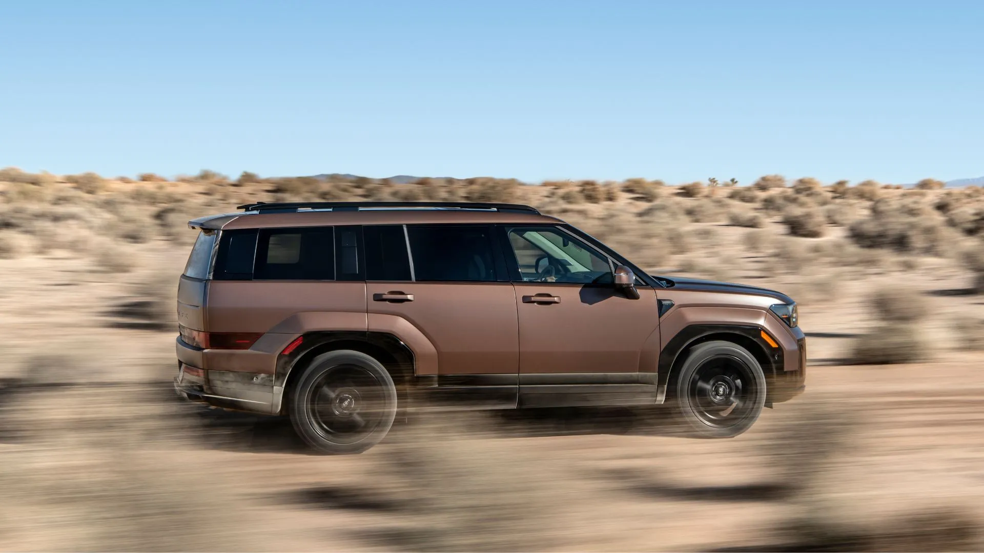 Hông xe Hyundai Santa Fe Hybrid 2025 màu đồng di chuyển off-road
