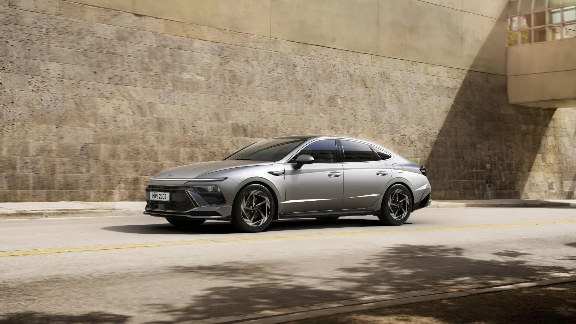 Hyundai Sonata 2025 màu bạc đỗ cạnh bức tường gạch