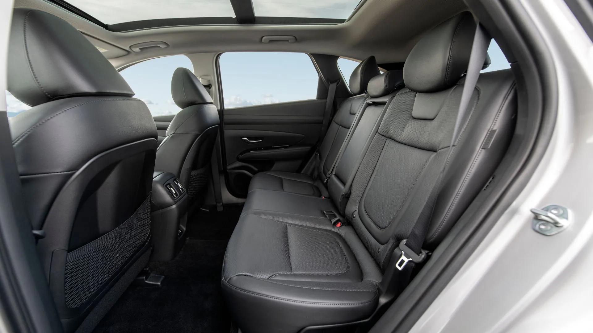 Khoang cabin phía sau rộng rãi với ghế da màu đen của Hyundai Tucson PHEV 2025.
